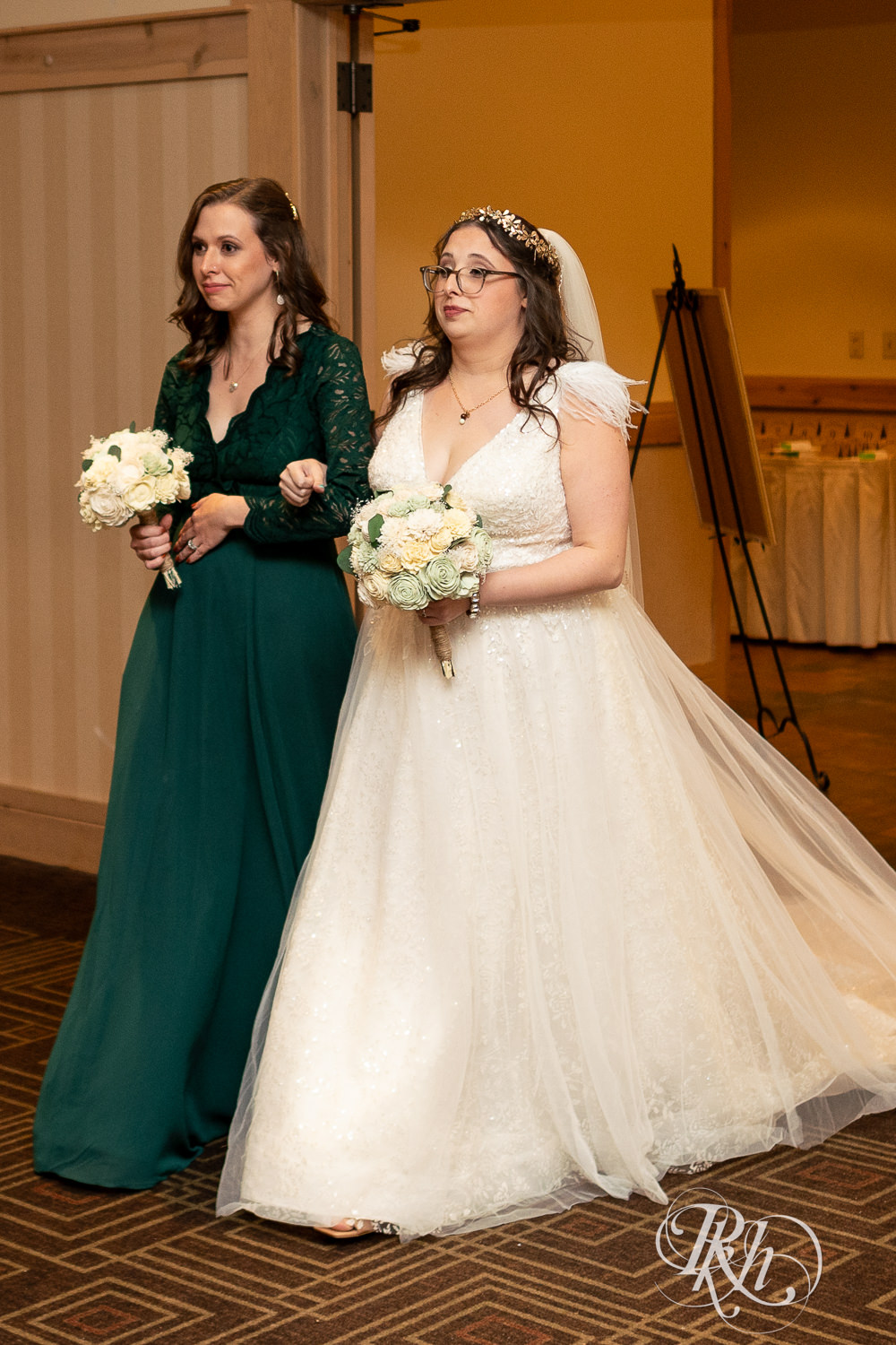 Bride walks down the aisle with her sister at Bunker Hills Event Center in Coon Rapids, Minnesota.