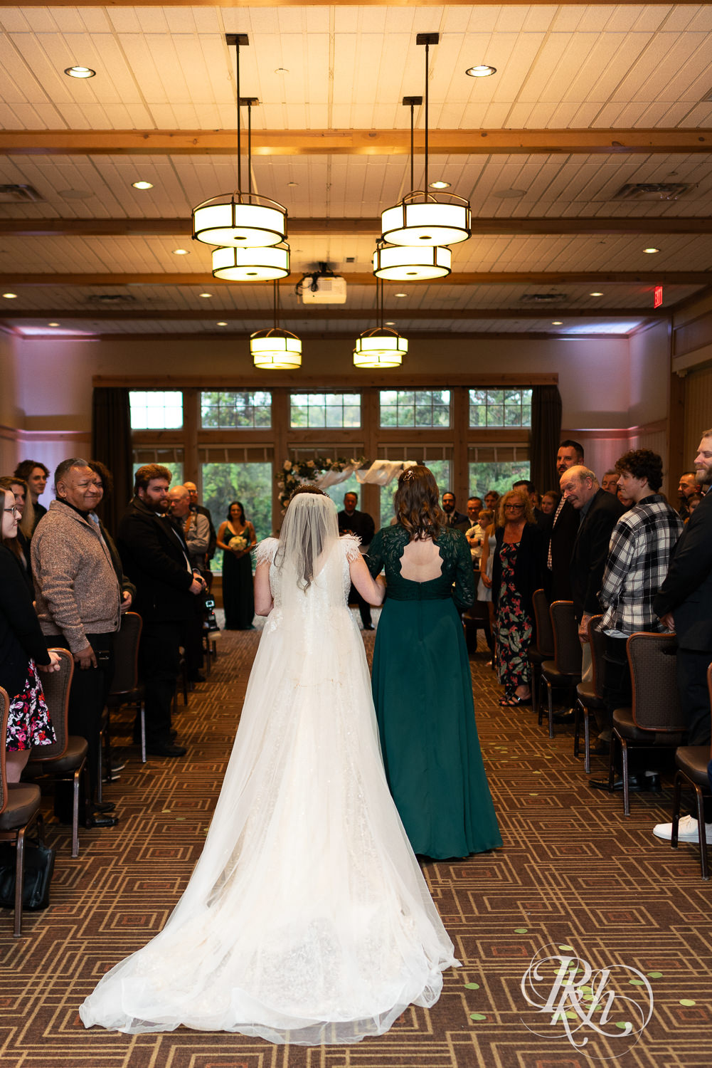 Bride walks down the aisle with her sister at Bunker Hills Event Center in Coon Rapids, Minnesota.