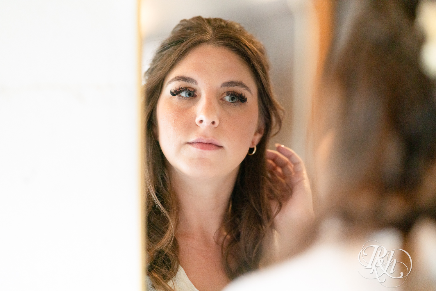 Bride looking in the mirror on wedding day at Hayvn at Hay River in Boyceville, Wisconsin. 