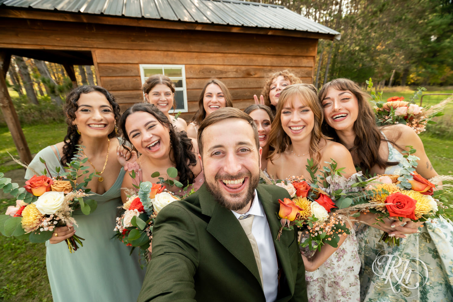 Groom smiles with wedding party on wedding day at Hayvn at Hay River in Boyceville, Wisconsin. 