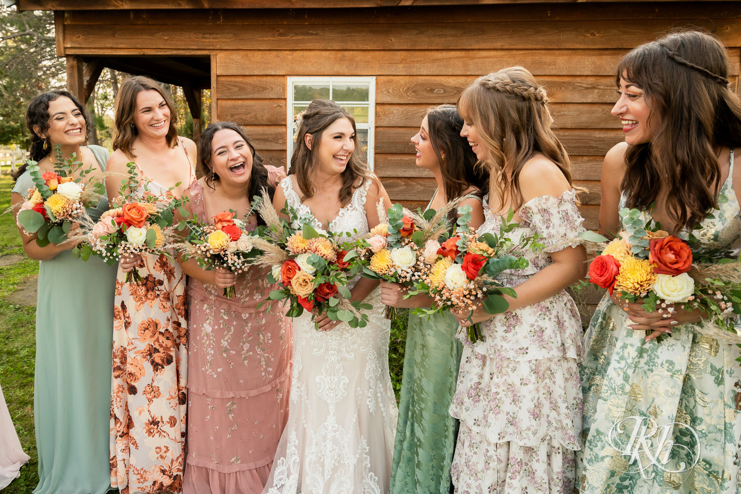 Bride smiles with wedding party on wedding day at Hayvn at Hay River in Boyceville, Wisconsin. 