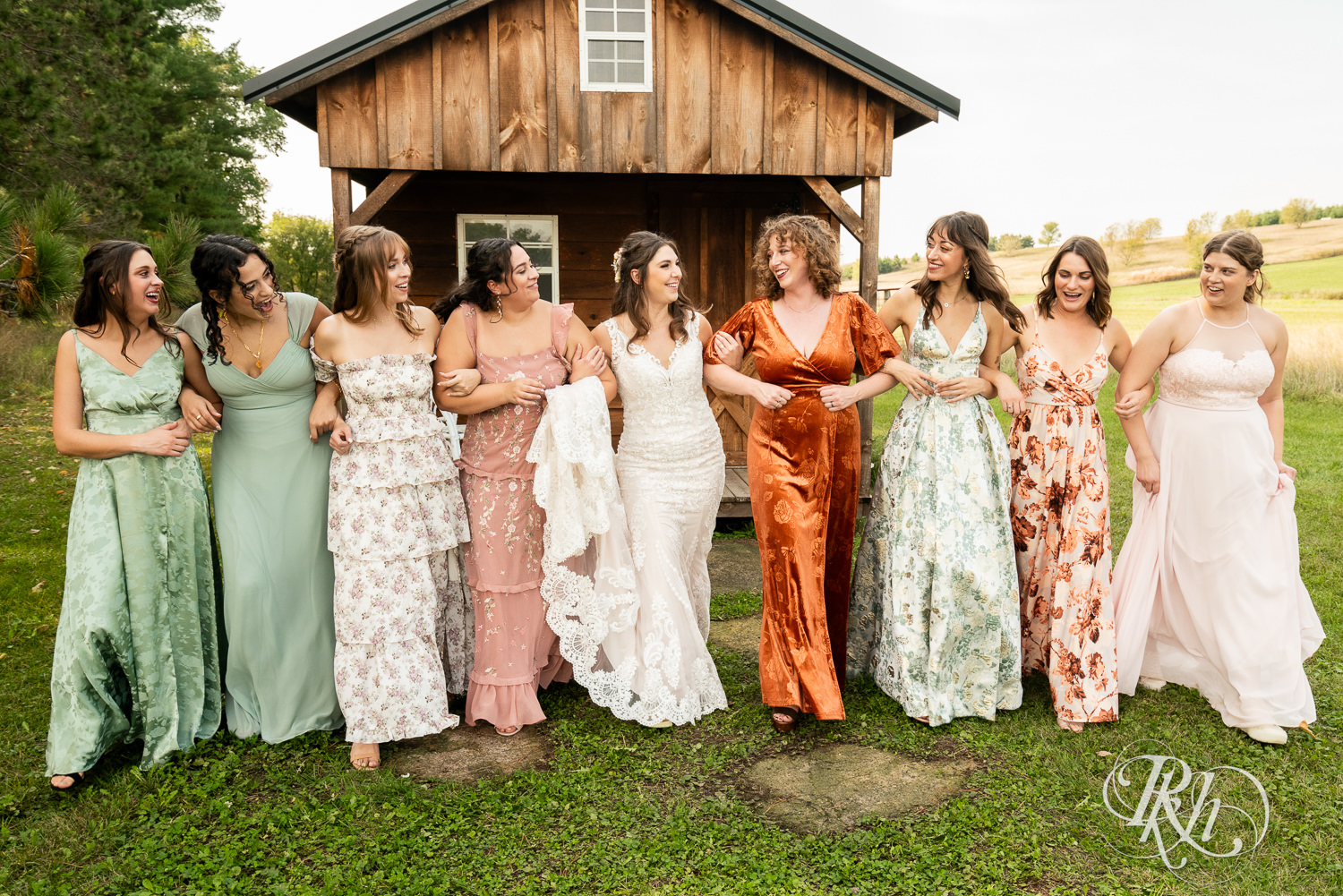 Bride smiles with wedding party on wedding day at Hayvn at Hay River in Boyceville, Wisconsin. 