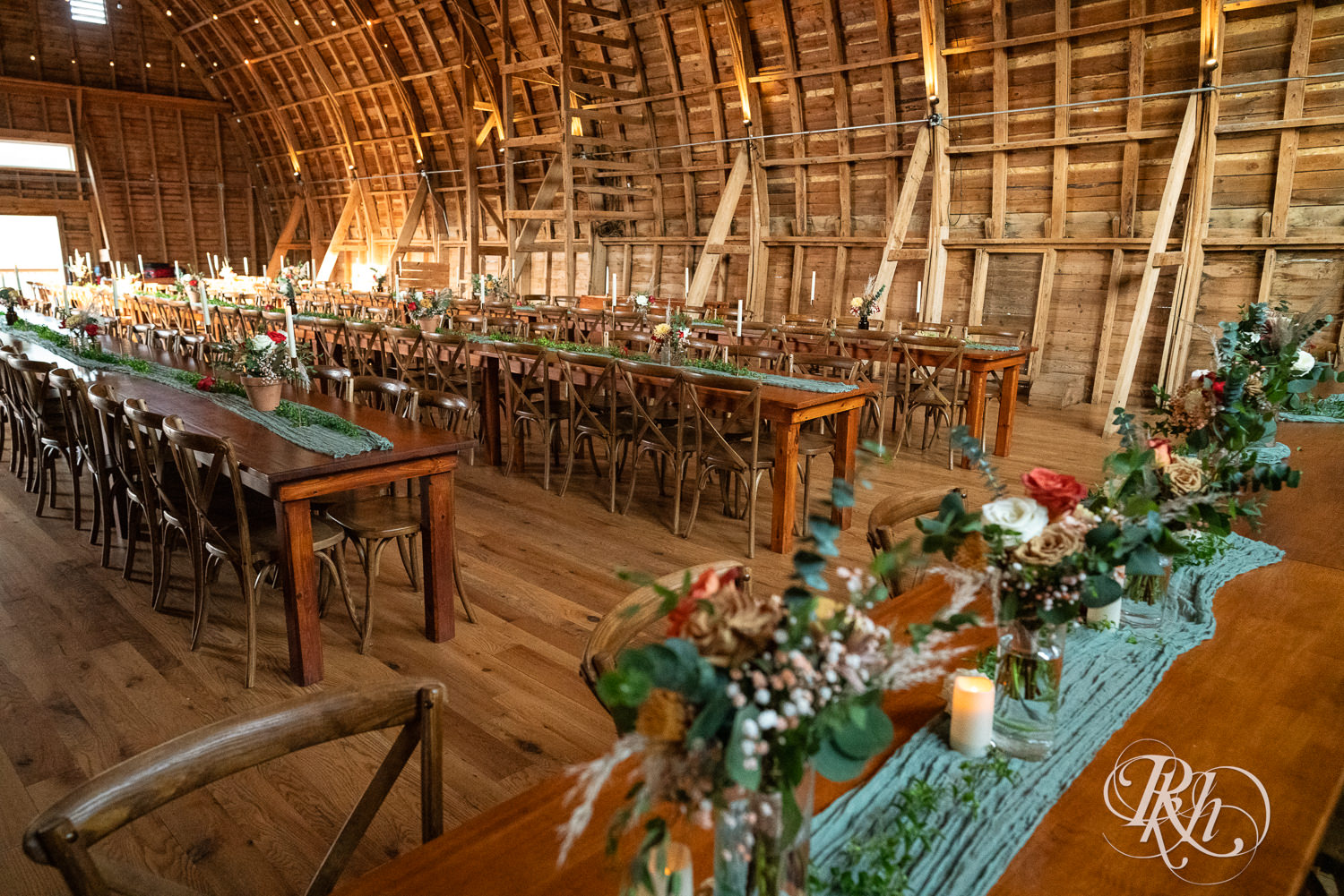 Indoor barn wedding reception setup at Hayvn at Hay River in Boyceville, Wisconsin. 