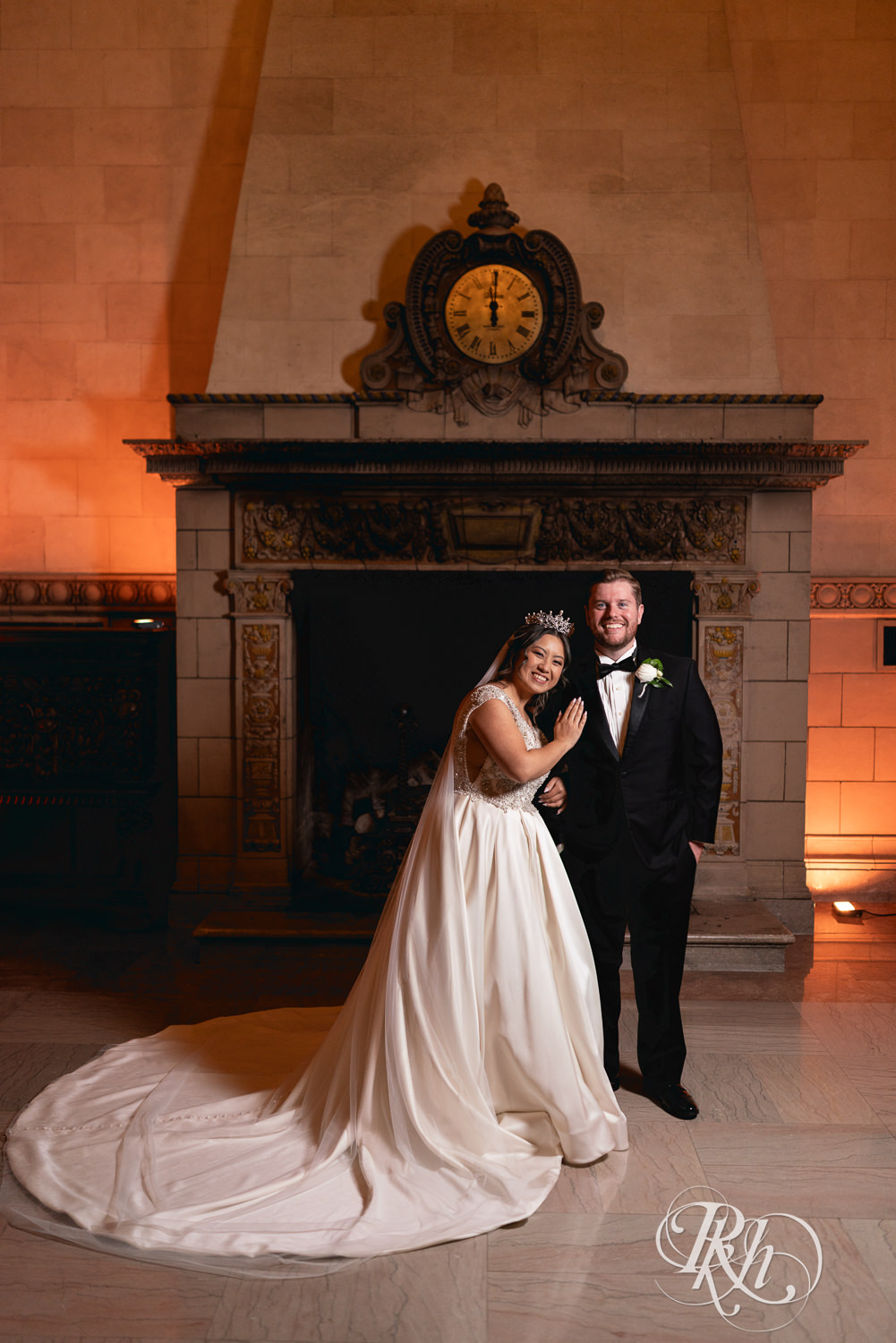 Hmong bride and groom smile in front of fireplace at the Saint Paul Athletic Club in Saint Paul, Minnesota.