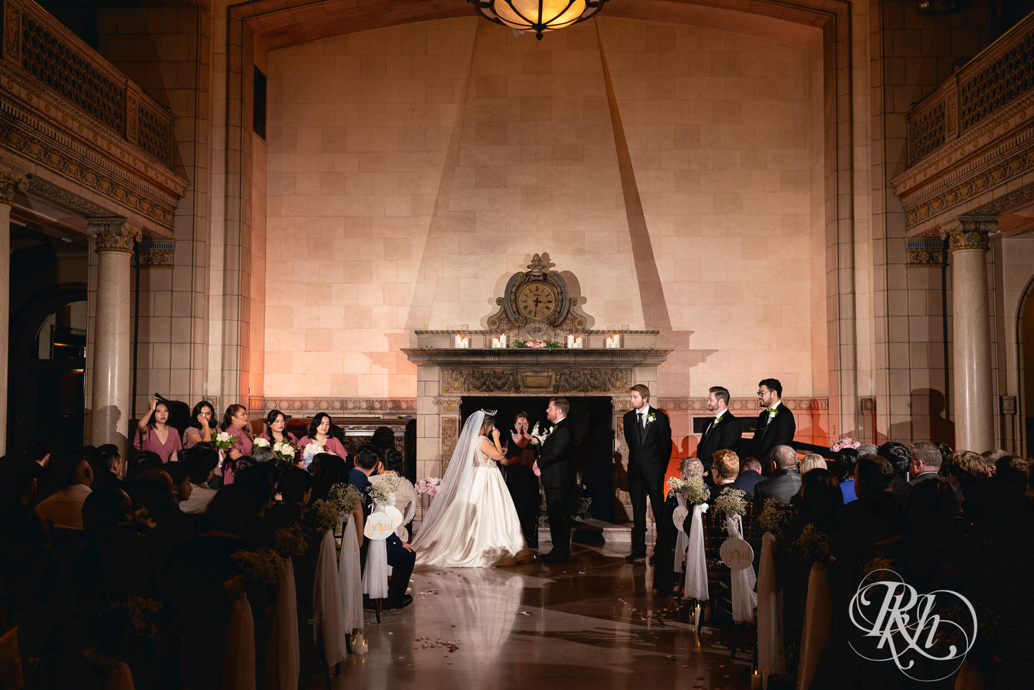 Hmong bride and groom hold hands during wedding ceremony at the Saint Paul Athletic Club in Saint Paul, Minnesota.