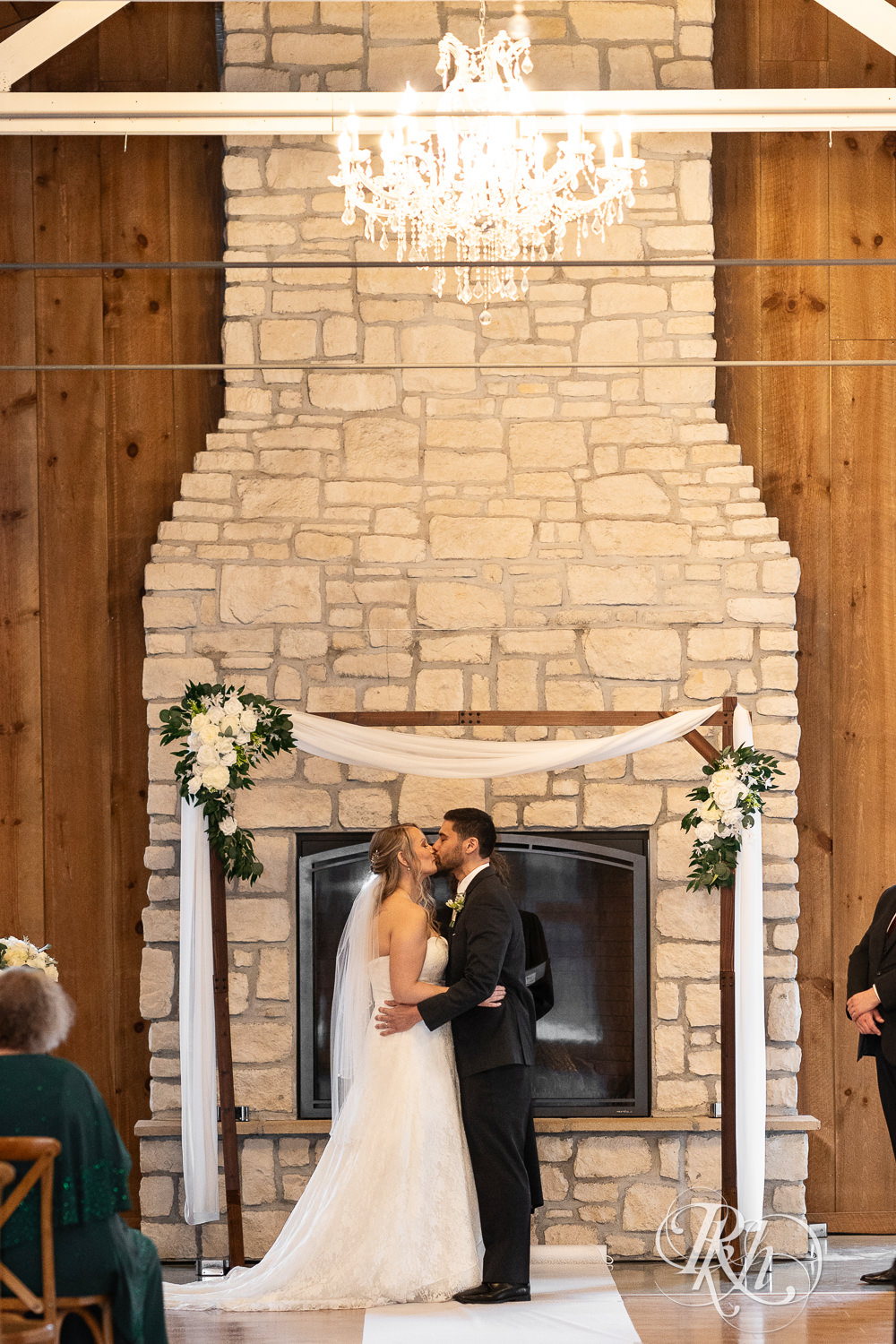 Bride and groom kiss during wedding ceremony at Almquist Farm in Hastings, Minnesota.