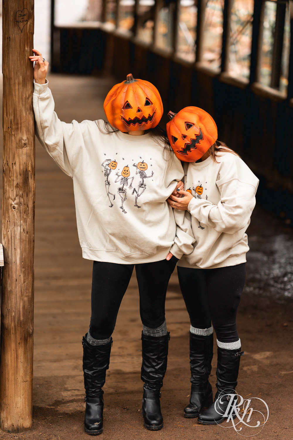 Lesbian couple pose in pumpkin heads during Halloween engagement photos at Amnicon Falls in Wisconsin. 