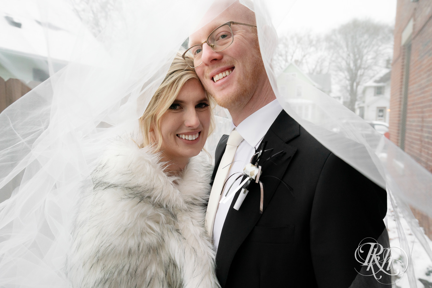 Bride and groom smile under veil at Gatherings at Station 10 in Saint Paul, Minnesota on winter wedding day.