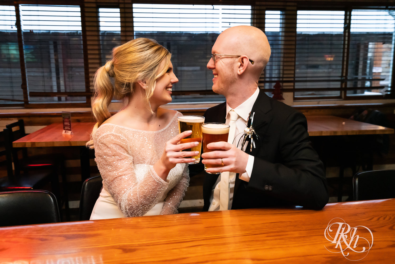 Bride and groom share a beer at the bar in Saint Paul, Minnesota.