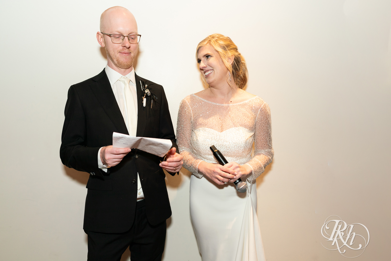 Bride and groom smile during wedding reception at Gatherings at Station 10 in Saint Paul, Minnesota.