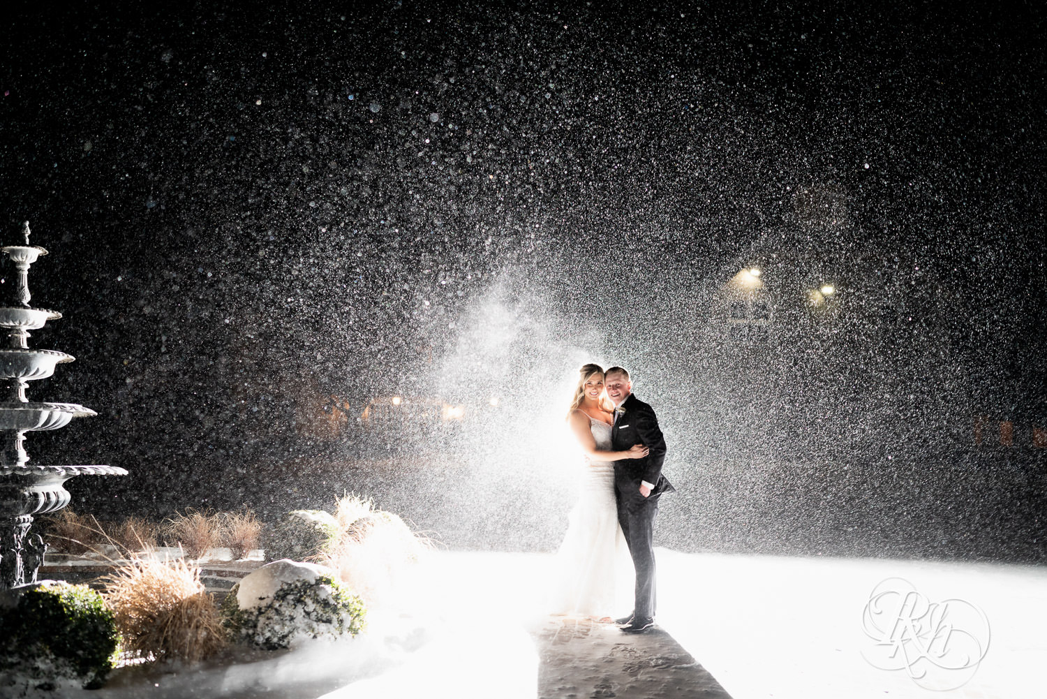 Bride and groom smile in the snow at night at Bavaria Downs in Chaska, Minnesota.