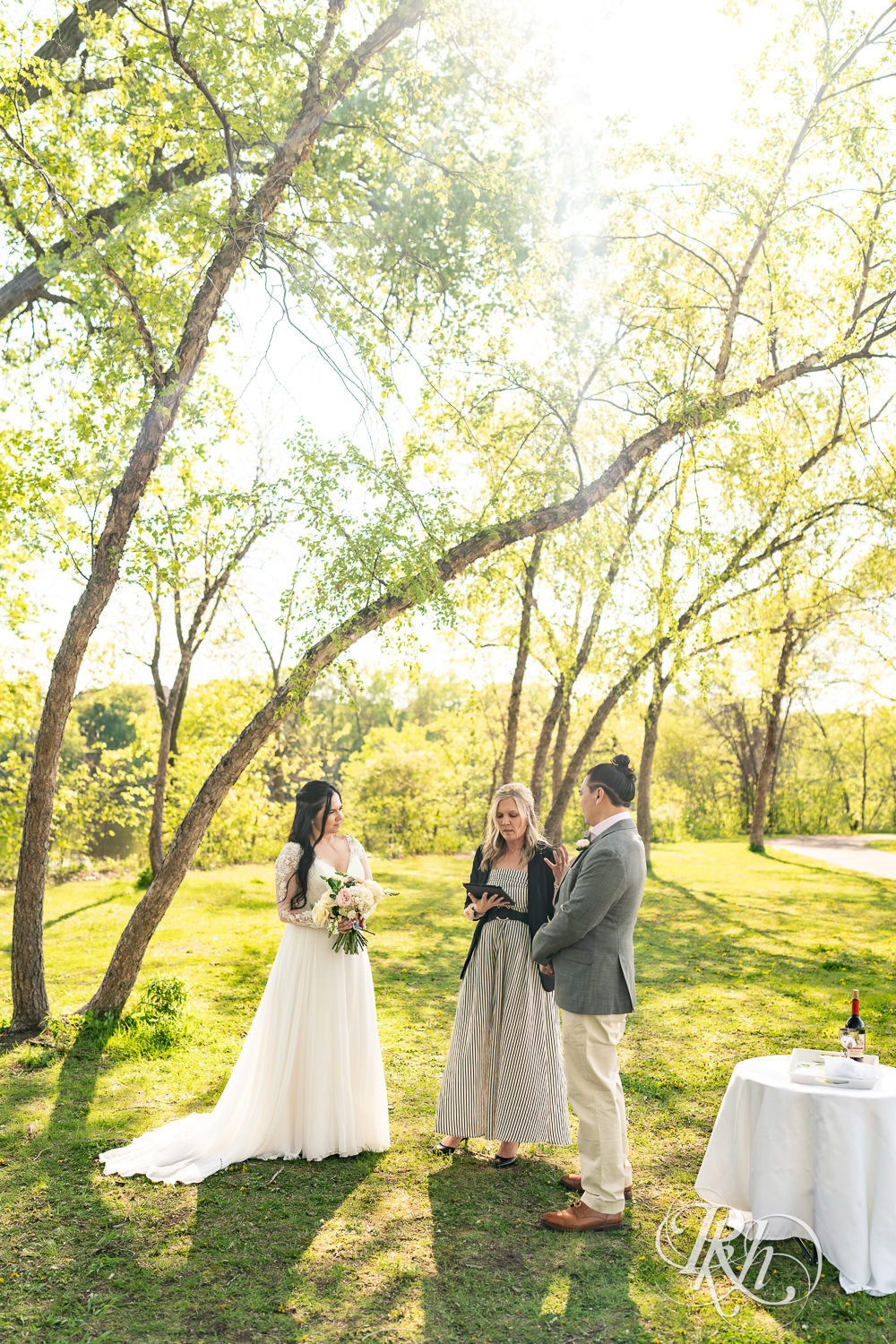 Bride and groom kiss on during wedding ceremony in Boom Island Park in Minneapolis, Minnesota.