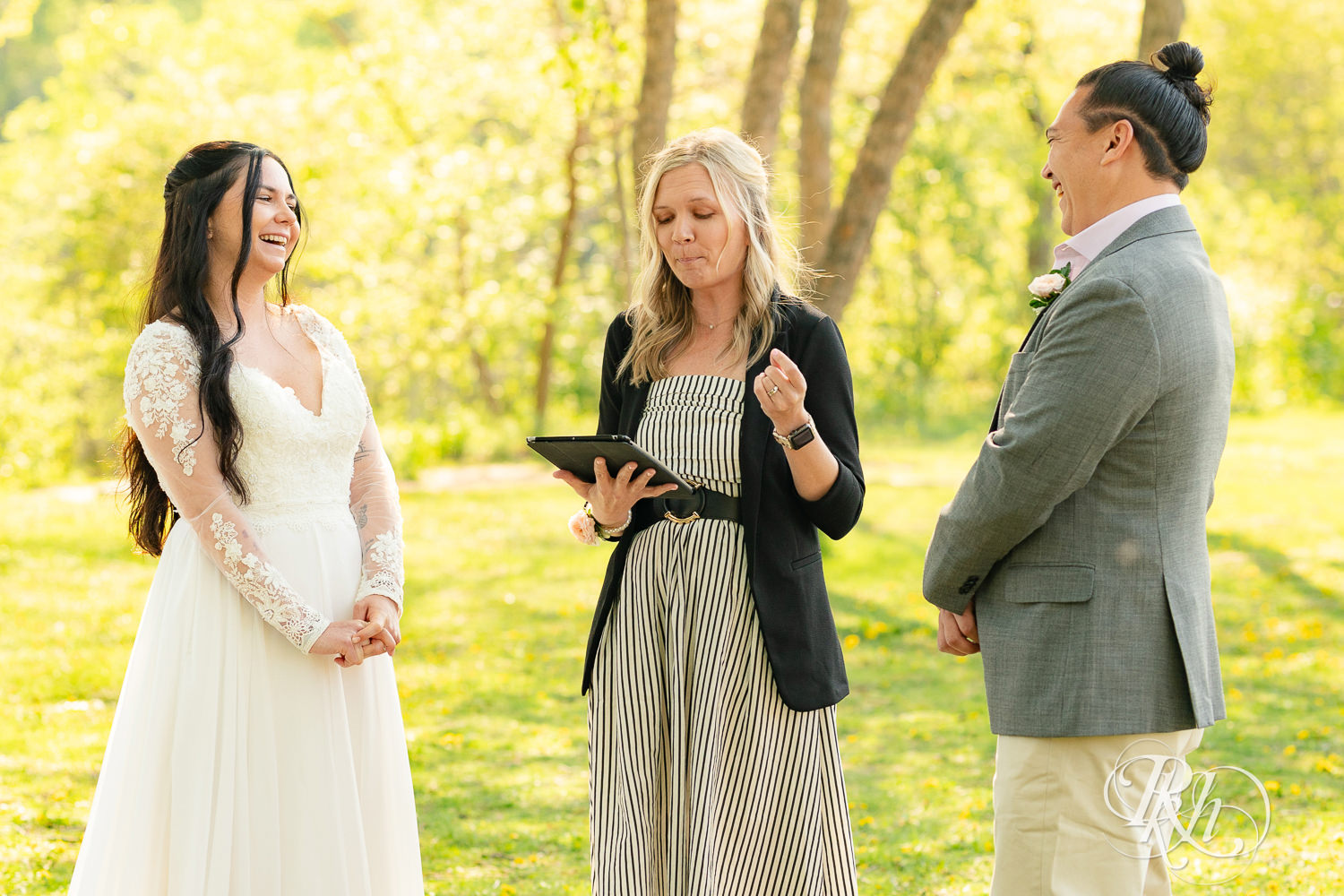 Bride and groom kiss on during wedding ceremony in Boom Island Park in Minneapolis, Minnesota.