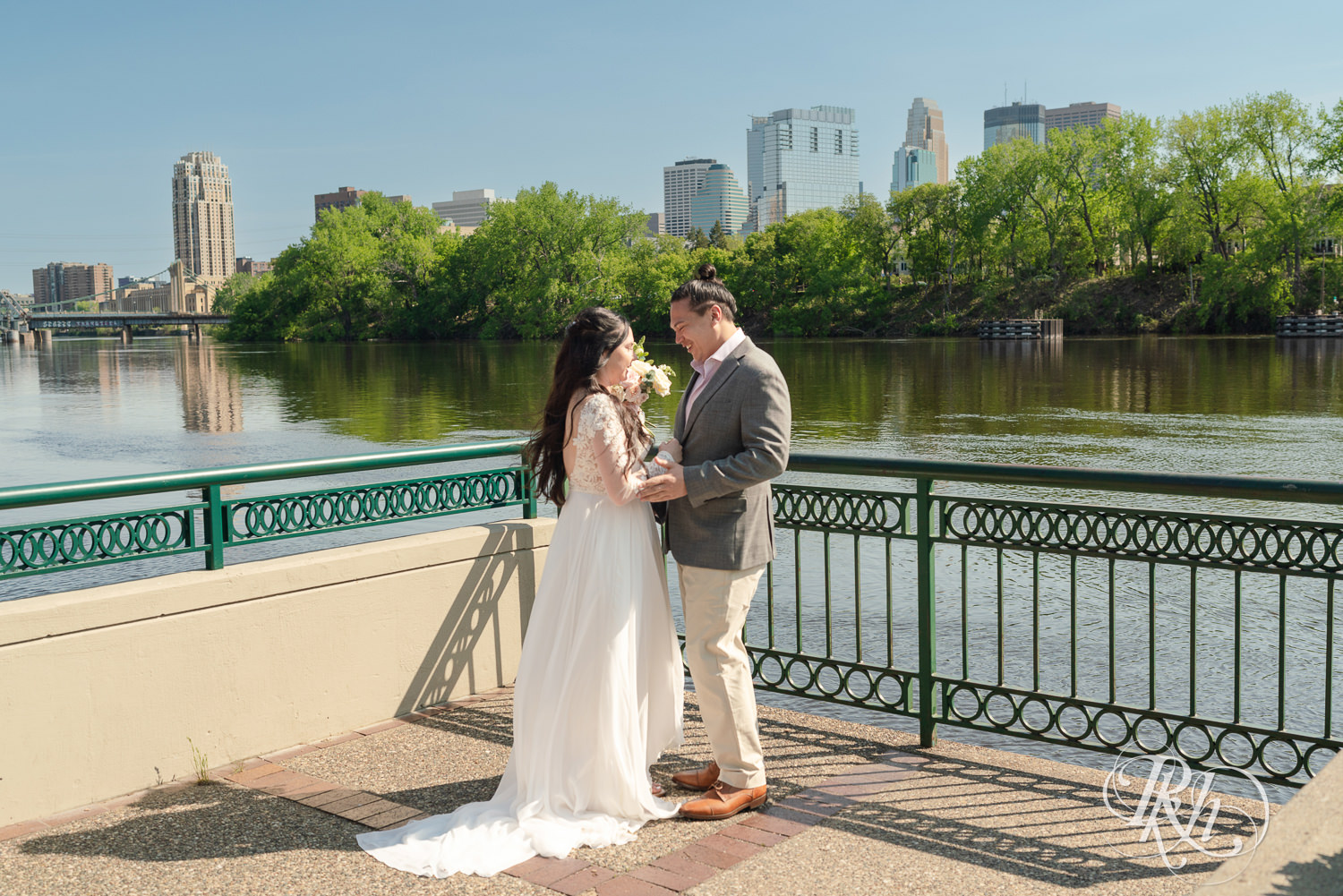 Bride and groom kiss on wedding day in Boom Island Park in Minneapolis, Minnesota.
