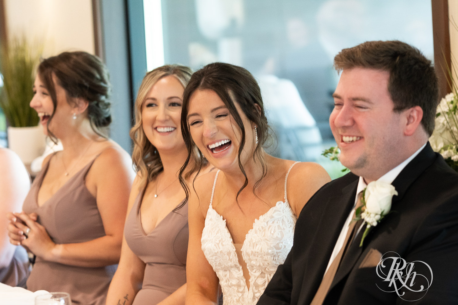 Bride and groom laugh during wedding reception at Olympic Hills Golf Club in Eden Prairie, Minnesota.