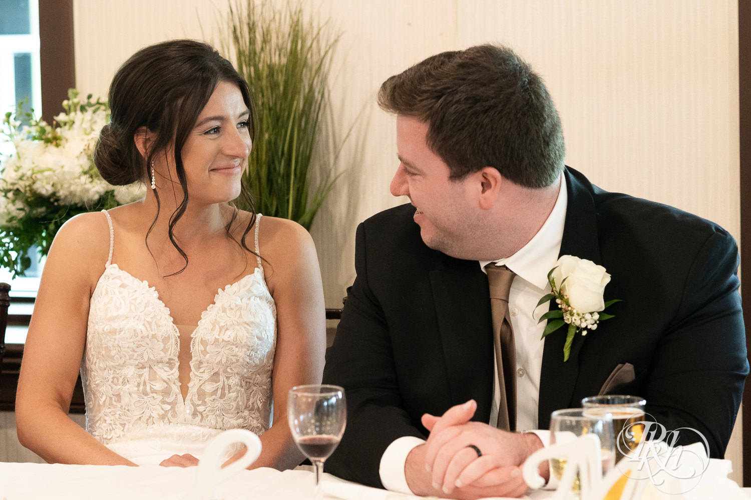 Bride and groom smile during wedding reception at Olympic Hills Golf Club in Eden Prairie, Minnesota.