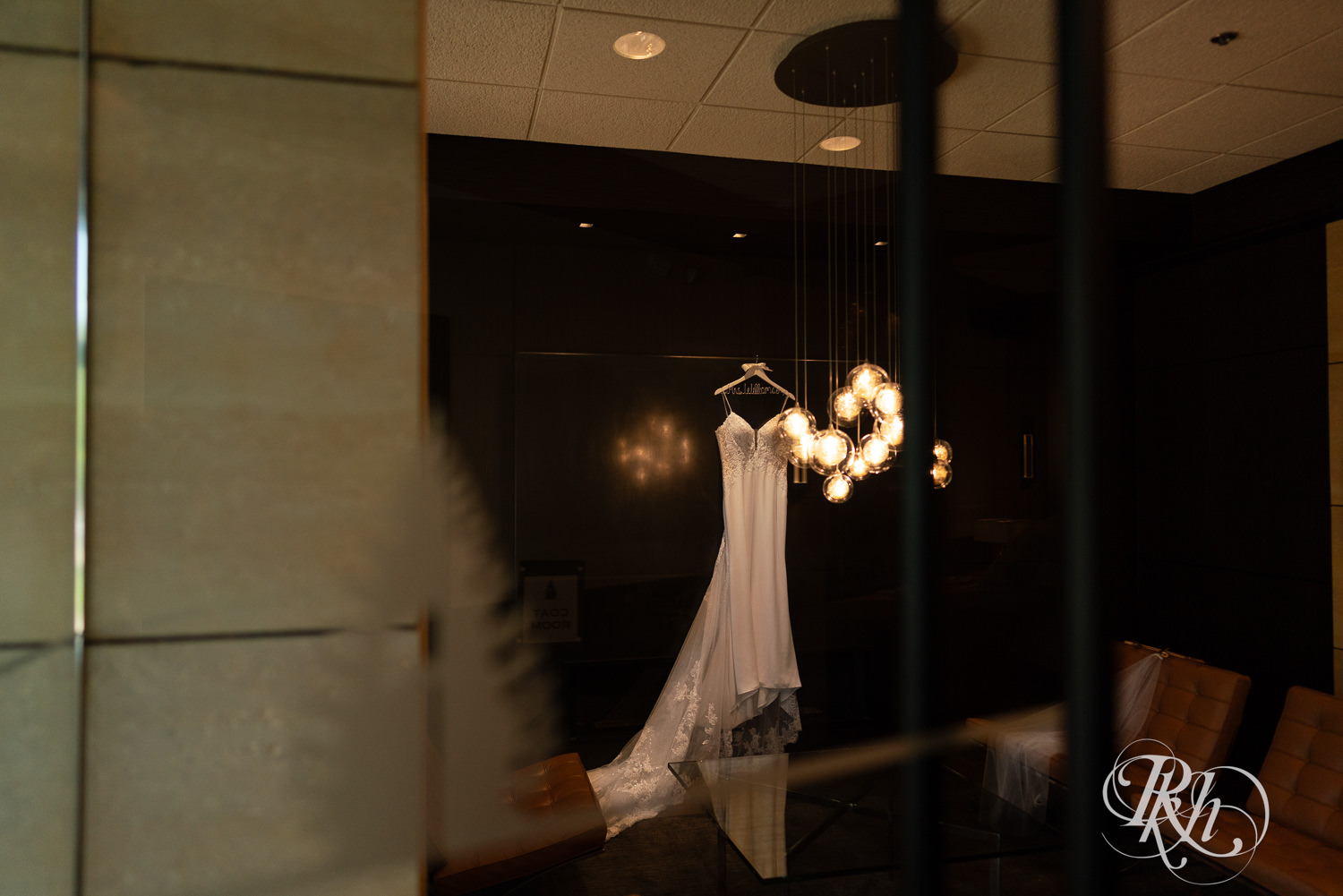 Wedding dress hung up on the wall photographed through glass at Olympic Hills Golf Club in Eden Prairie, Minnesota.