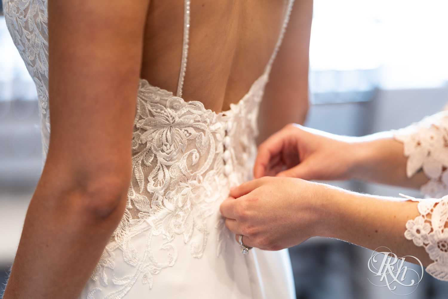 Bride getting into her wedding dress at Olympic Hills Golf Club in Eden Prairie, Minnesota.