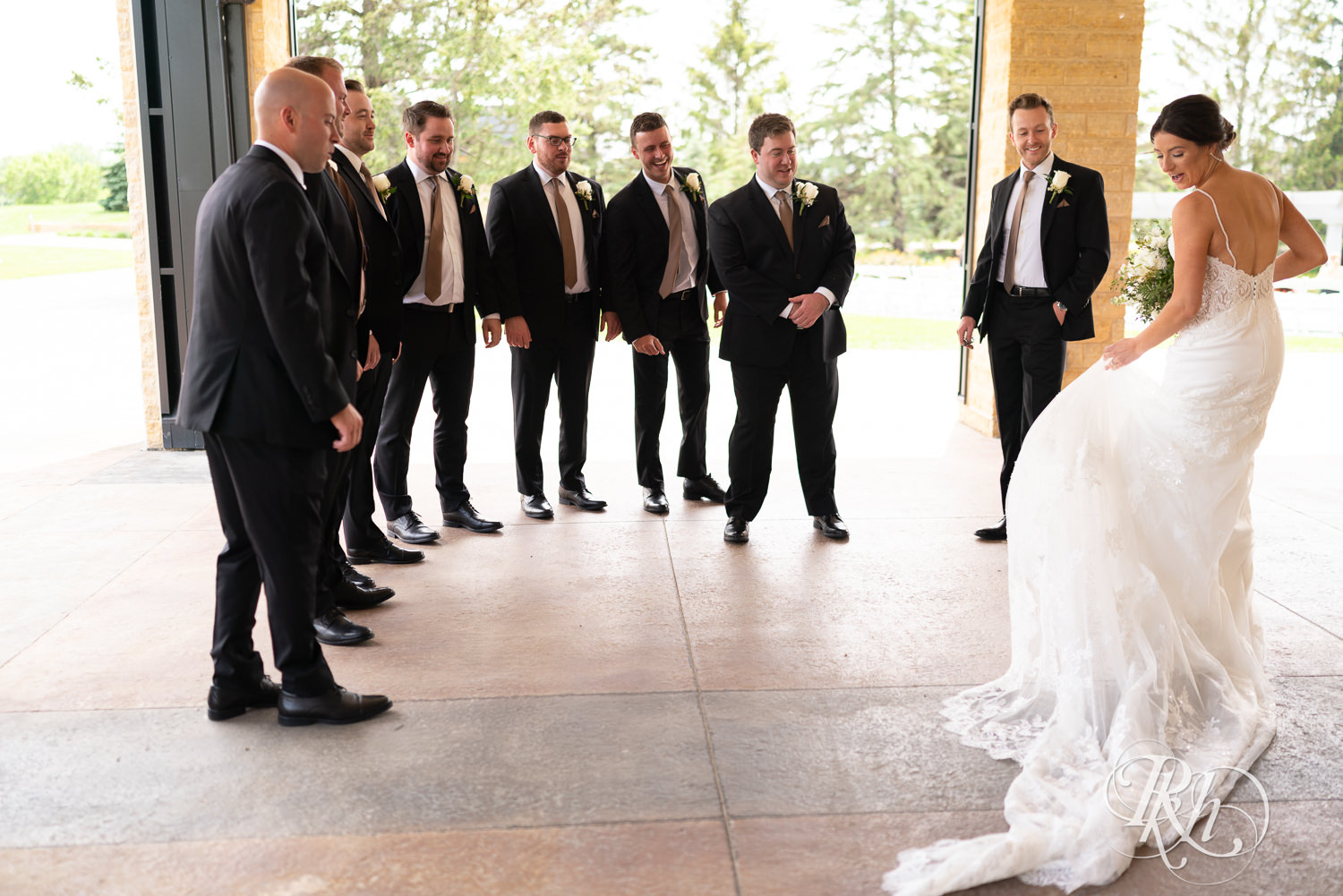 Bride shares first look with groomsmen at Olympic Hills Golf Club in Eden Prairie, Minnesota.