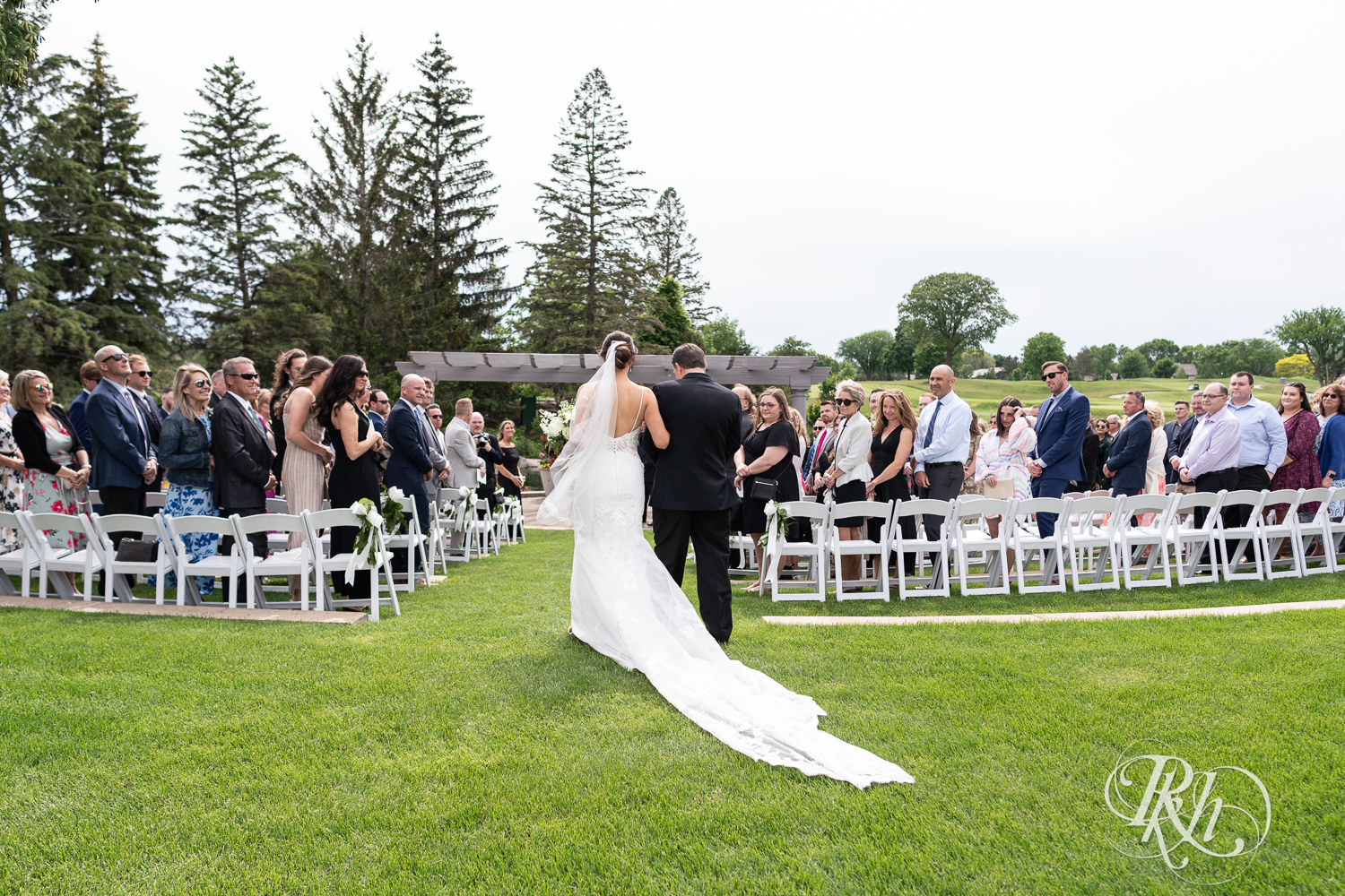 Bride walks down the aisle with her dad at Olympic Hills Golf Club in Eden Prairie, Minnesota.