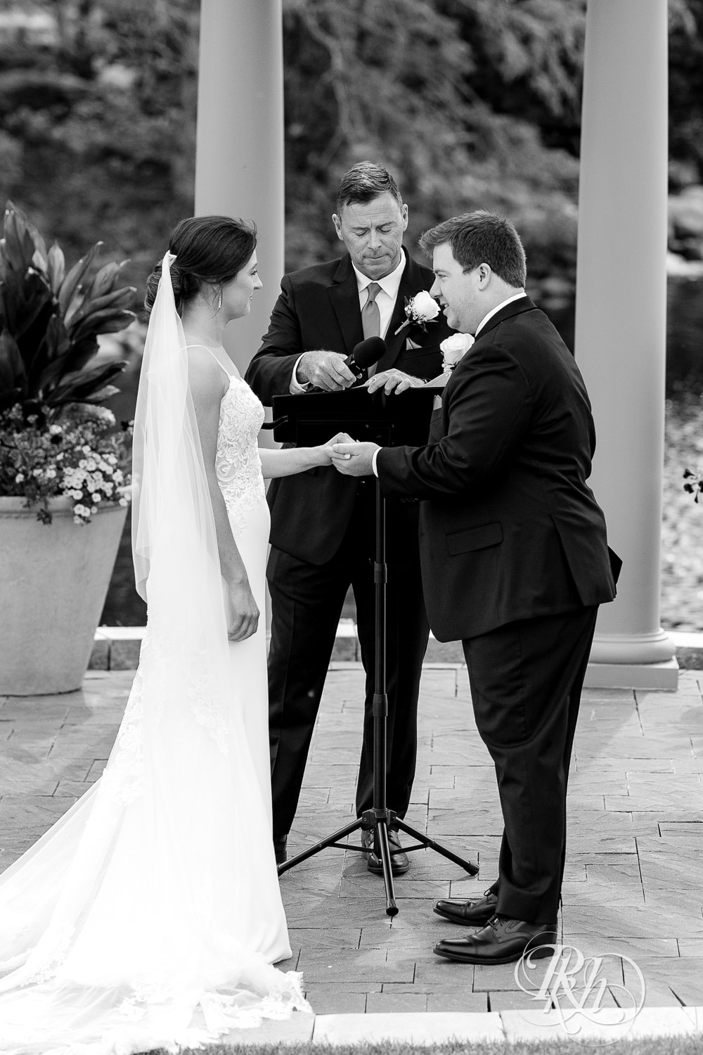 Bride and groom smile during wedding ceremony at Olympic Hills Golf Club in Eden Prairie, Minnesota.