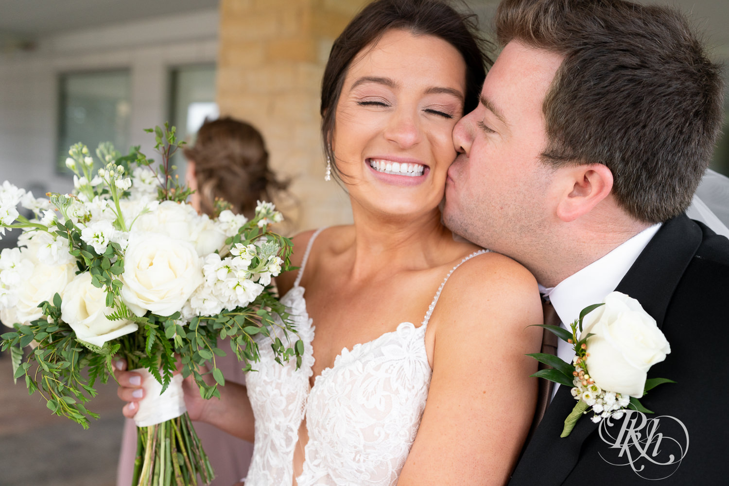 Groom kisses bride on the cheek after they are married at Olympic Hills Golf Club in Eden Prairie, Minnesota.