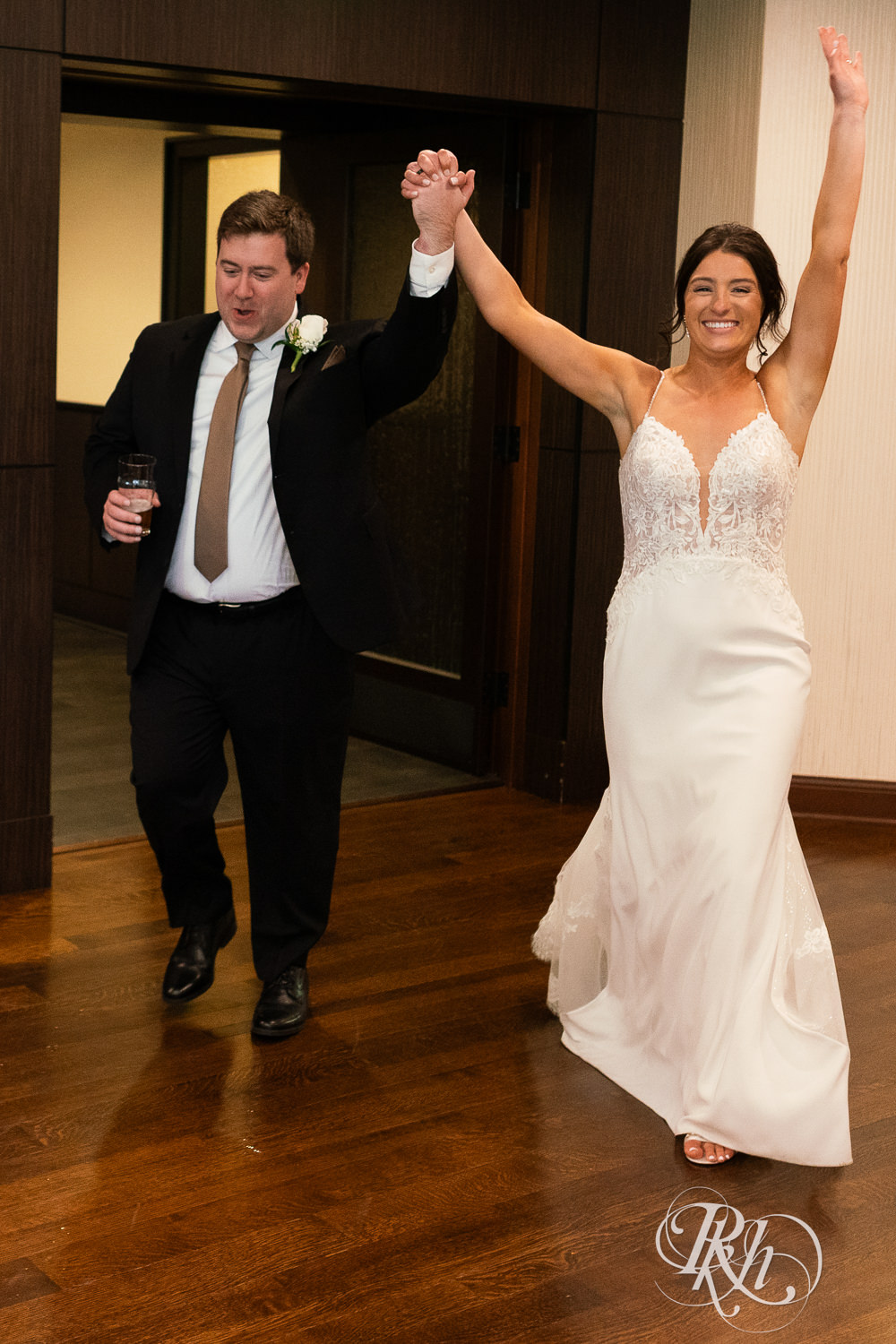 Bride and groom cheer during grand entrance at Olympic Hills Golf Club in Eden Prairie, Minnesota.