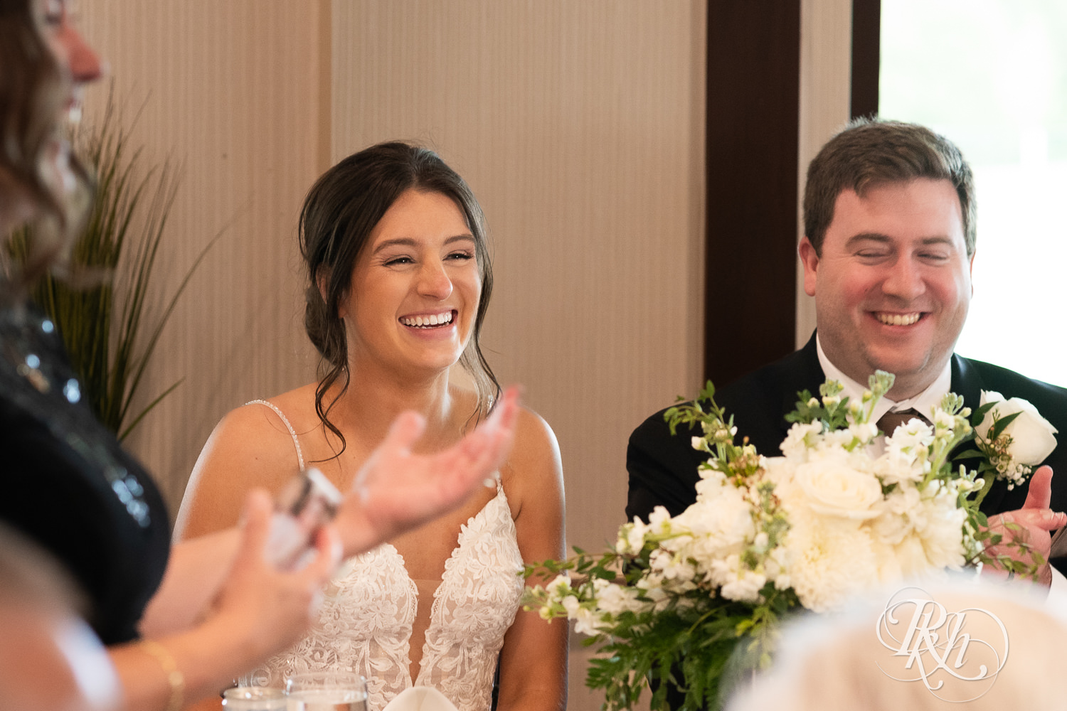 Bride and groom laugh during wedding reception at Olympic Hills Golf Club in Eden Prairie, Minnesota.