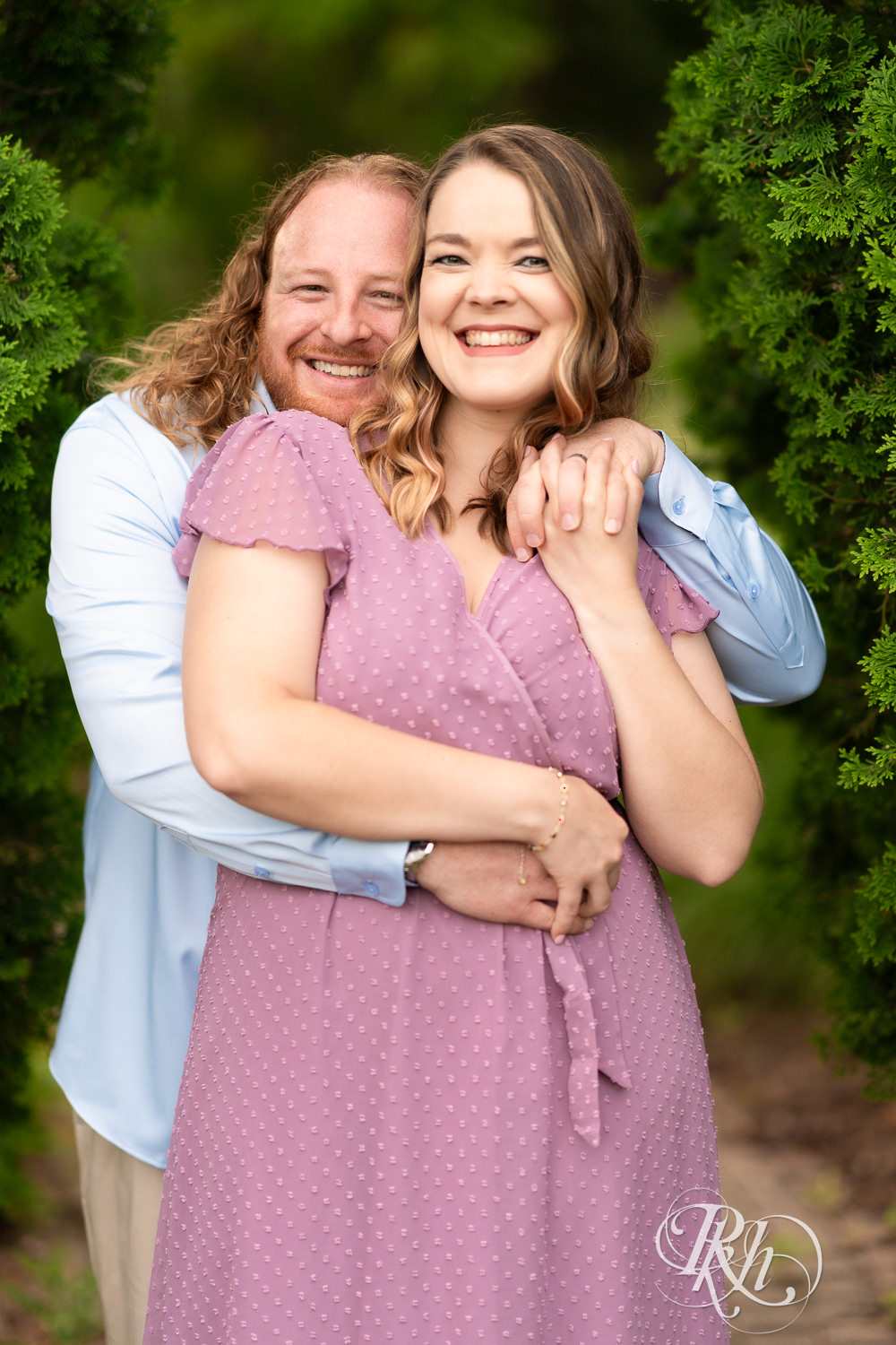 Man in blue shirt and woman in purple dress smile at sunset at Centennial Lakes Park in Edina, Minnesota.