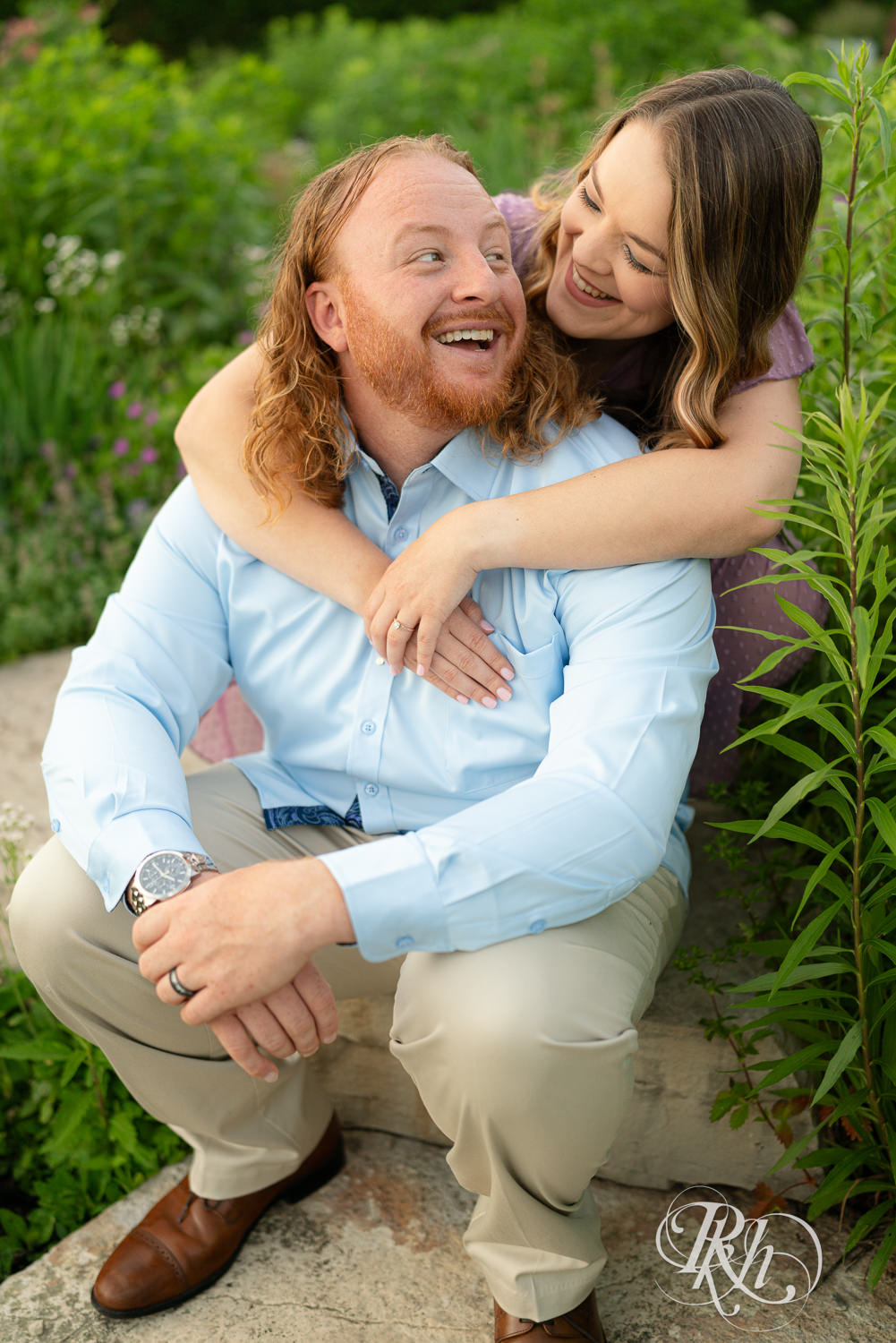 Man in blue shirt and woman in purple dress smile in a garden at Centennial Lakes Park in Edina, Minnesota.