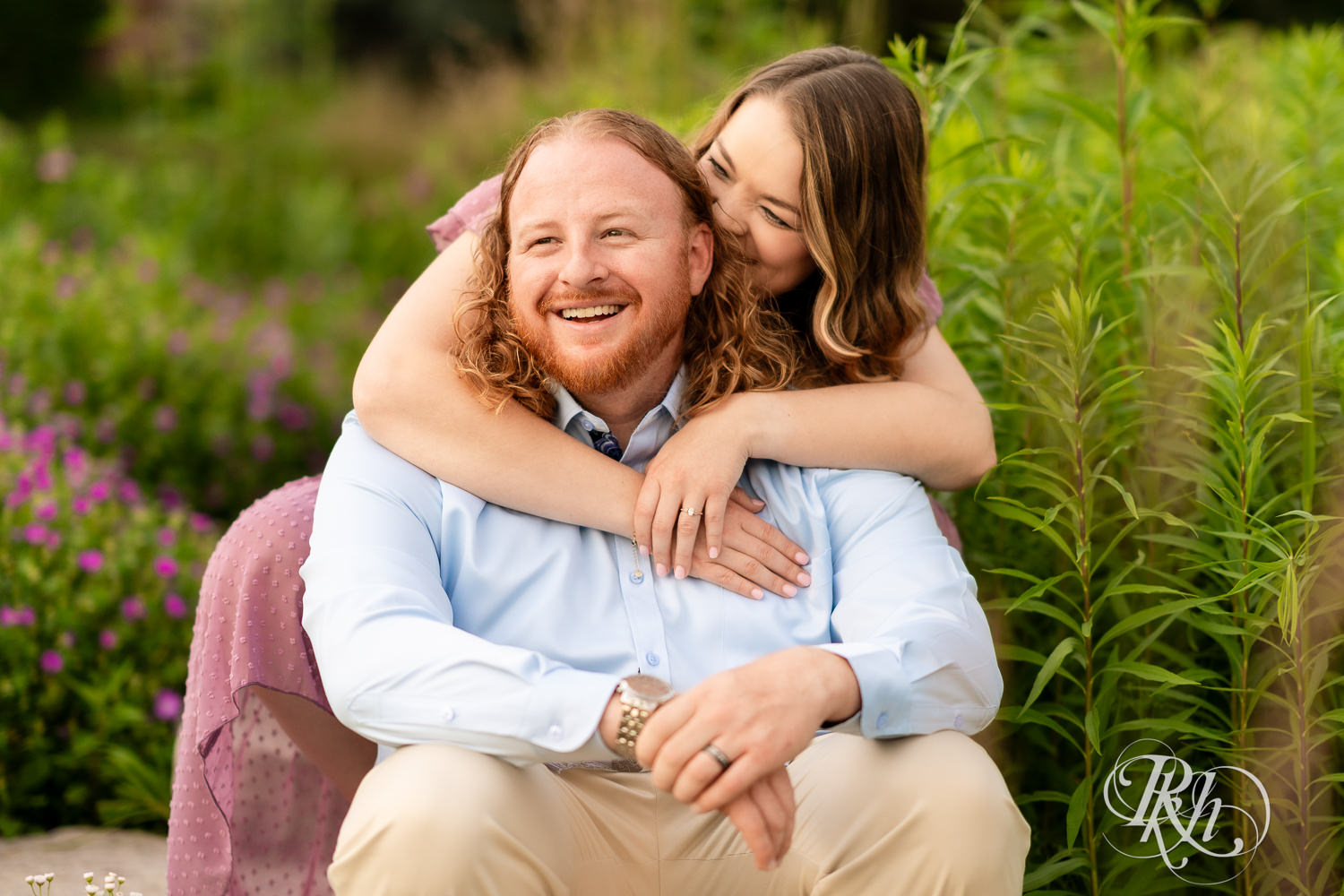 Man in blue shirt and woman in purple dress smile in a garden at Centennial Lakes Park in Edina, Minnesota.