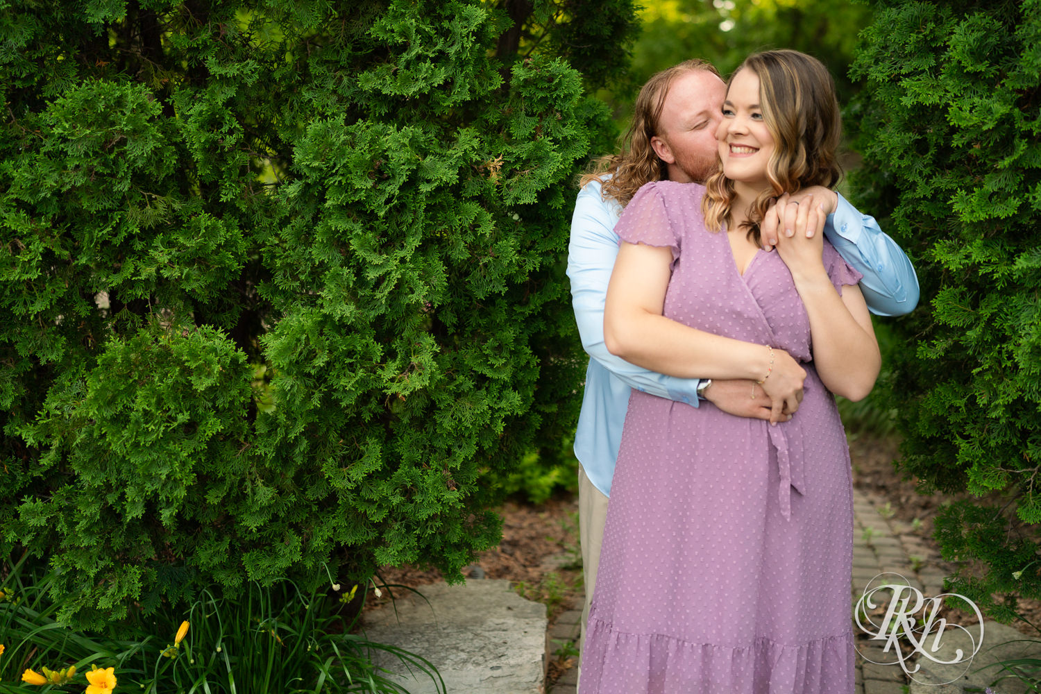 Man in blue shirt and woman in purple dress smile at sunset at Centennial Lakes Park in Edina, Minnesota.