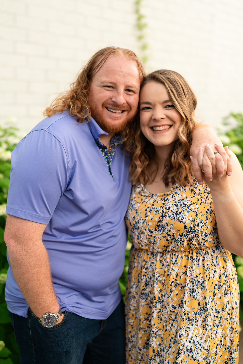 Man in blue shirt and woman in flower dress smile at Centennial Lakes Park in Edina, Minnesota.