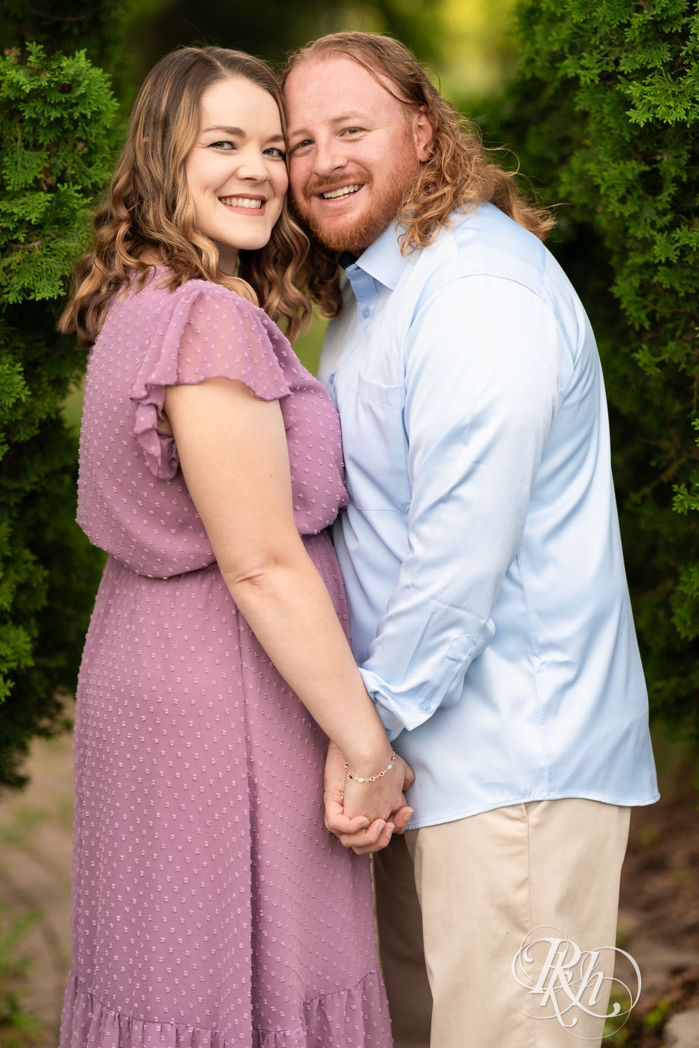 Man in blue shirt and woman in purple dress smile at sunset at Centennial Lakes Park in Edina, Minnesota.