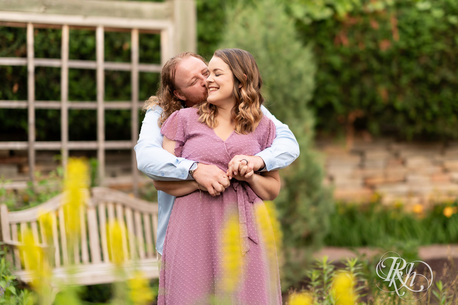 Man in blue shirt and woman in purple dress smile in a garden at Centennial Lakes Park in Edina, Minnesota.