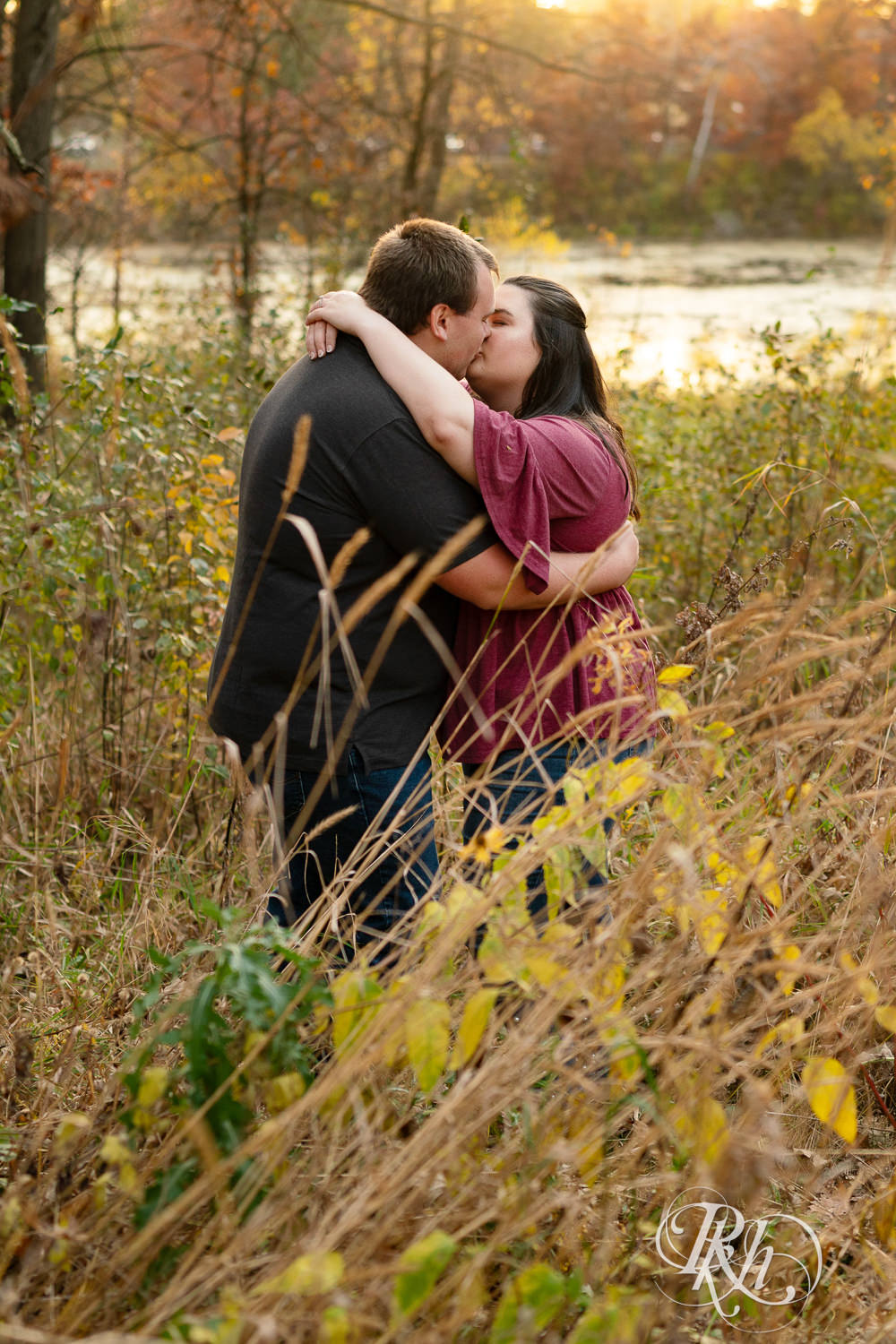 Plus size man and woman kiss in field at Lebanon Hills Regional Park in Eagan, Minnesota.