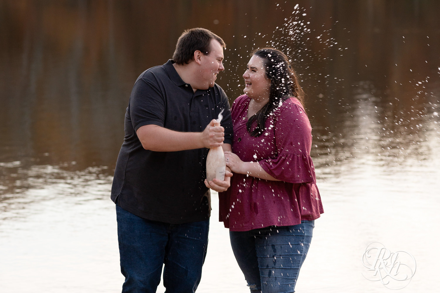 Plus size man and woman spray champagne on the beach at Lebanon Hills Regional Park in Eagan, Minnesota.