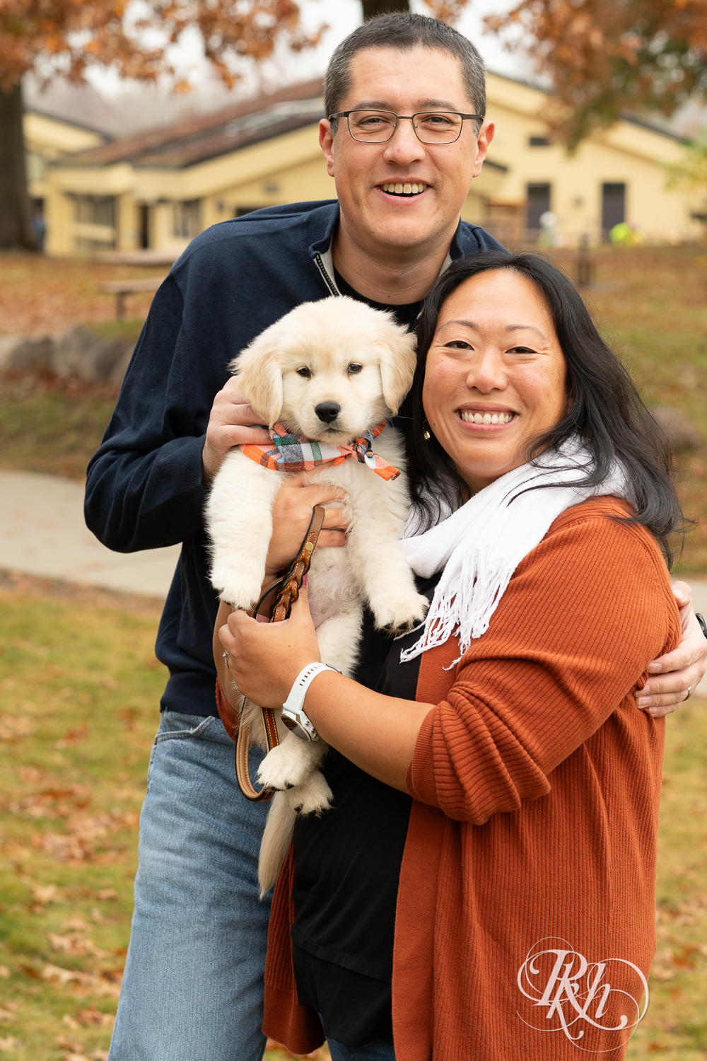 Man and woman smile with their Golden Retriever puppy at Lebanon Hills Regional Park in Eagan, Minnesota.