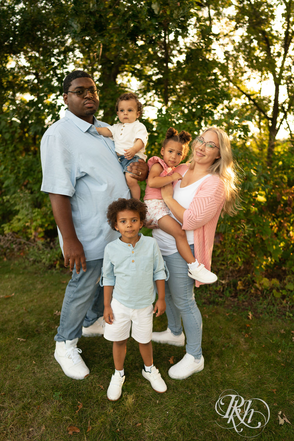 Black man and woman smile with their family of two sons and a daughter during sunset in Eagan, Minnesota.