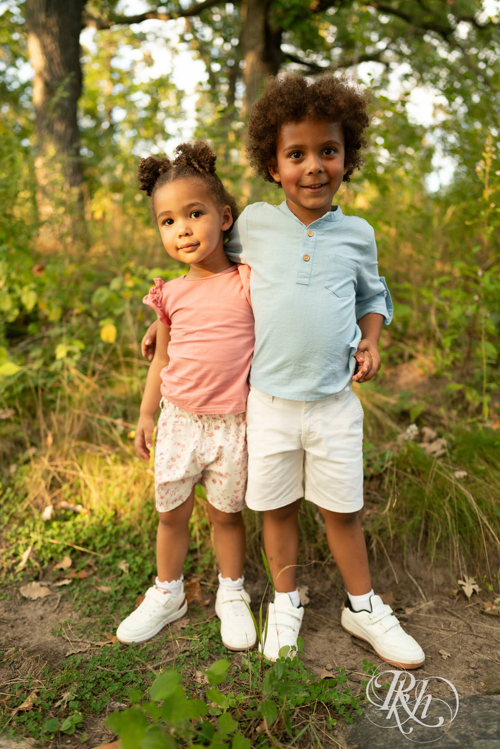 Little black boy and girl smile while standing on a rock during sunset in Eagan, Minnesota.