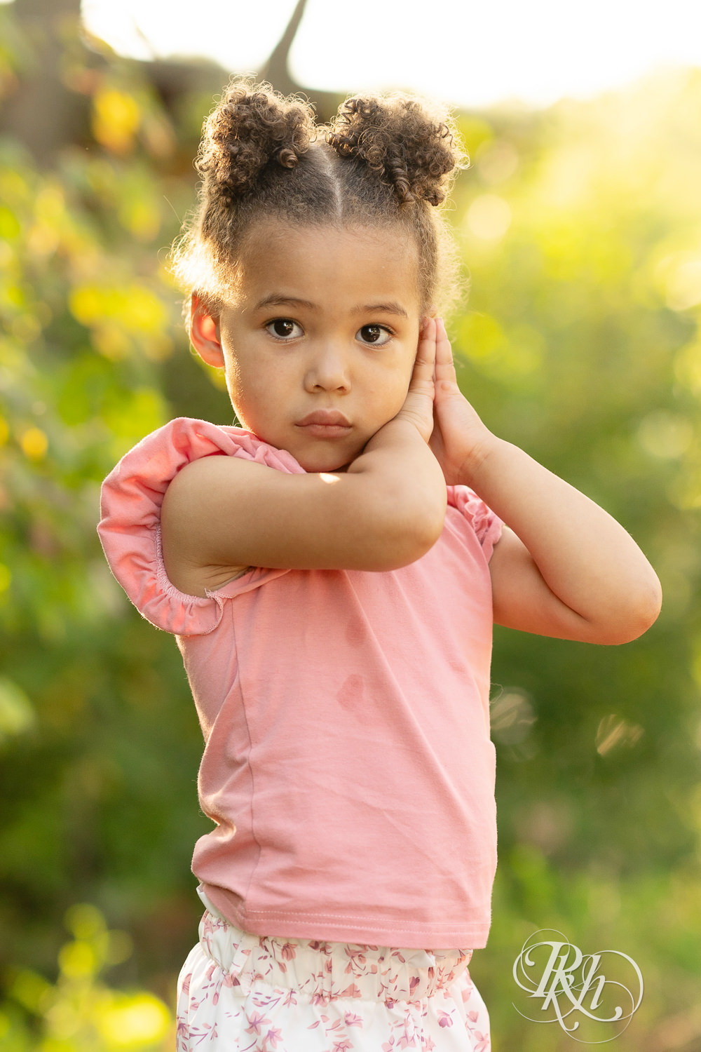 Little black girl dressed in pink smiles during sunset at Lebanon Hills Regional Park in Eagan, Minnesota.