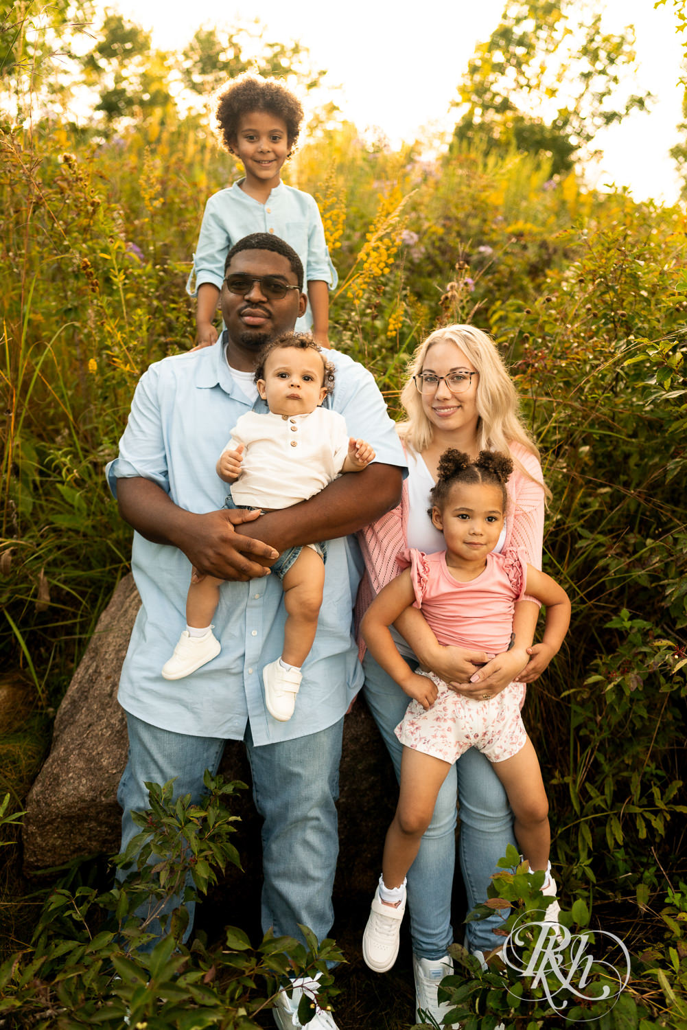 Black man and woman smile with their family of two sons and a daughter during sunset in Eagan, Minnesota.