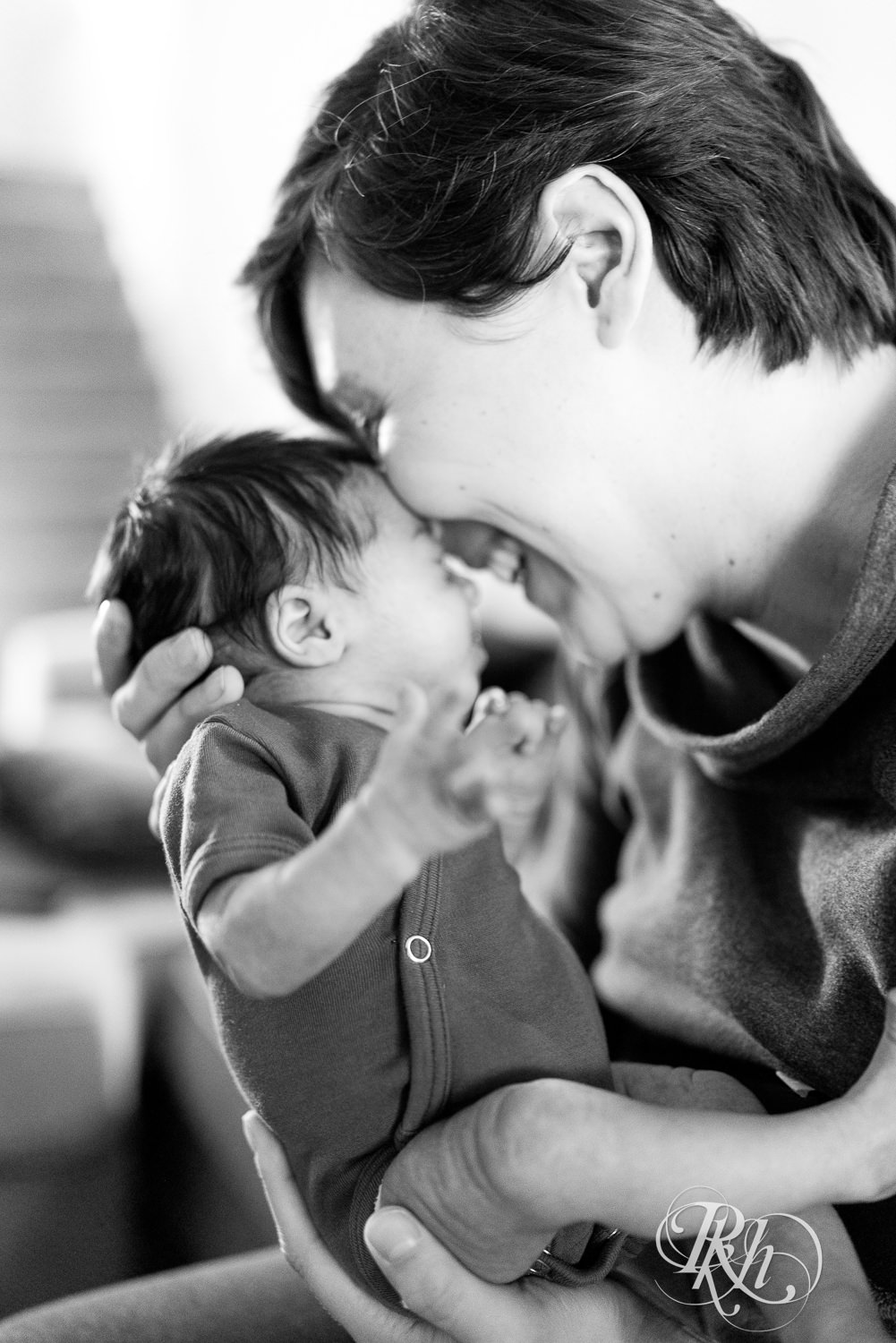 Mom laughs with newborn baby at her home in Saint Paul, Minnesota.