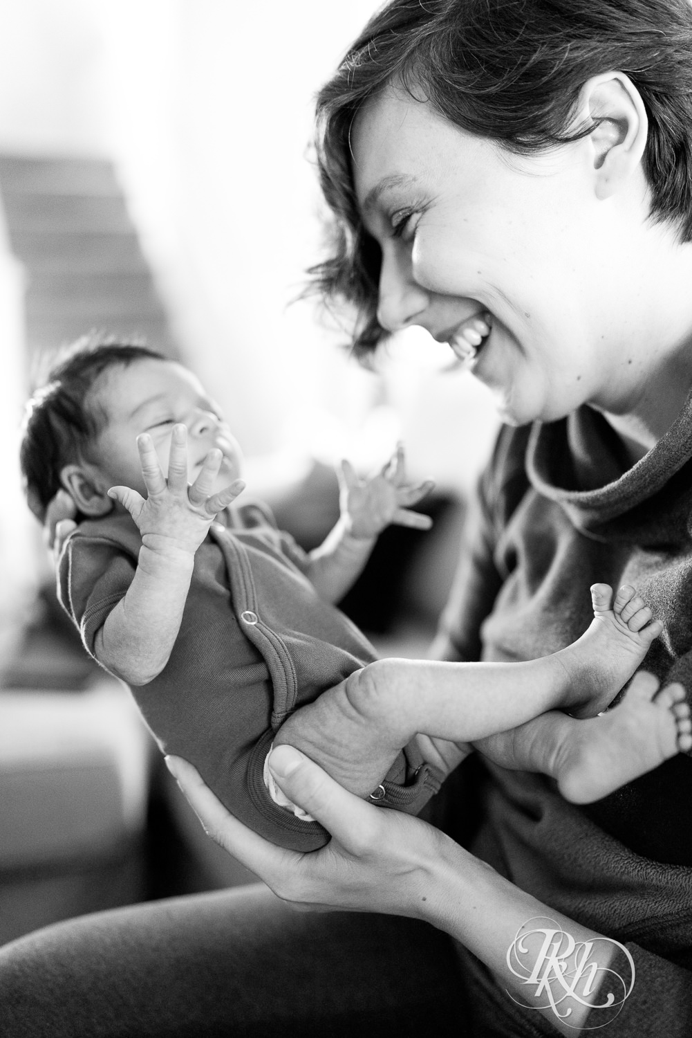 Mom laughs with newborn baby at her home in Saint Paul, Minnesota.