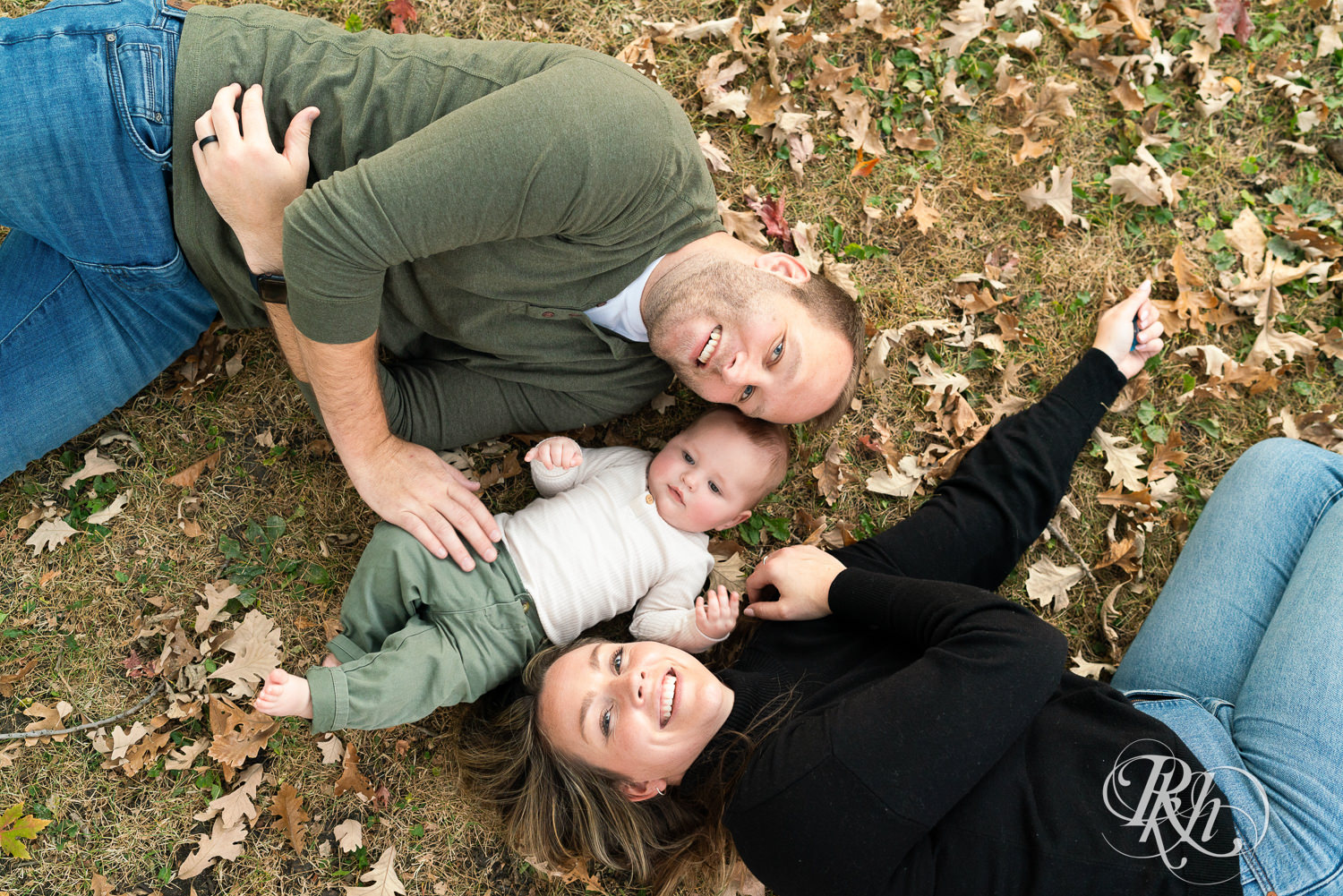 Mom and dad smile with baby during family photos at Irvine Park in Saint Paul, Minnesota.