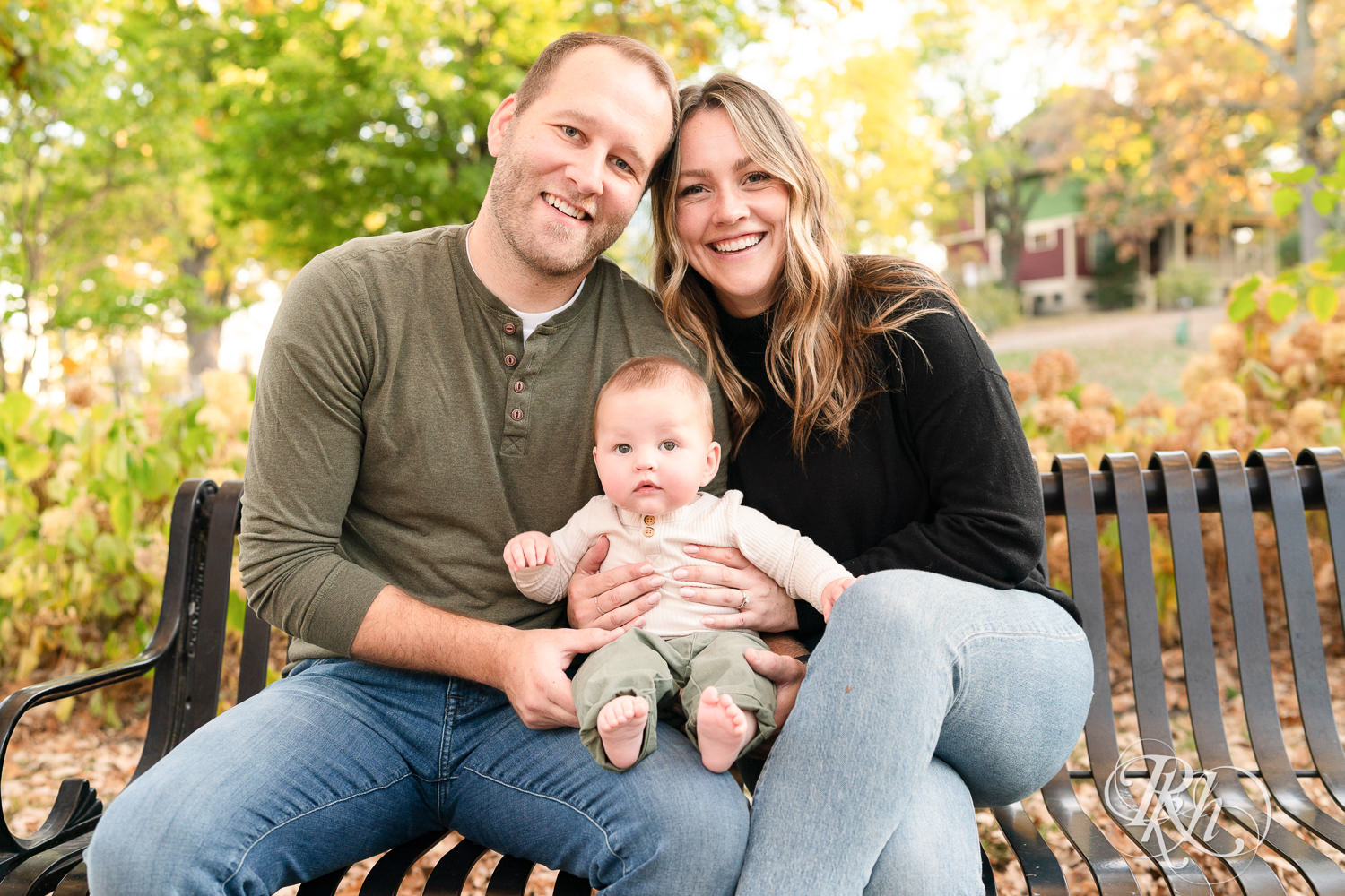 Mom and dad smile with baby during family photos at Irvine Park in Saint Paul, Minnesota.