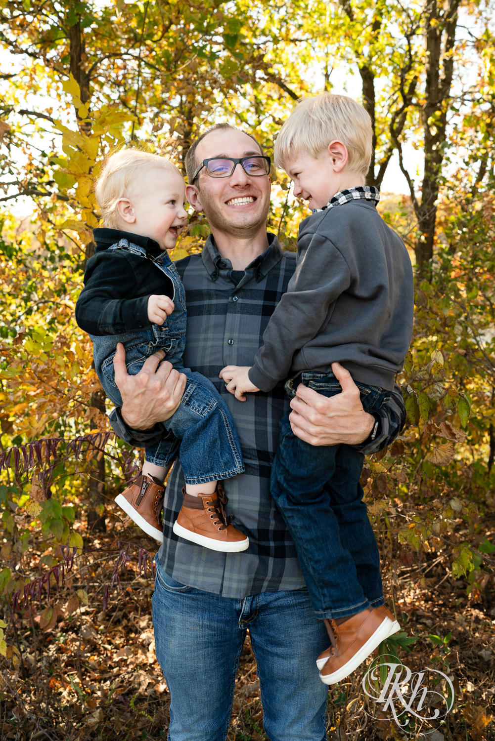 Dad and two little boys laugh during fall morning family photos in Lebanon Hills Regional Park in Eagan, Minnesota.