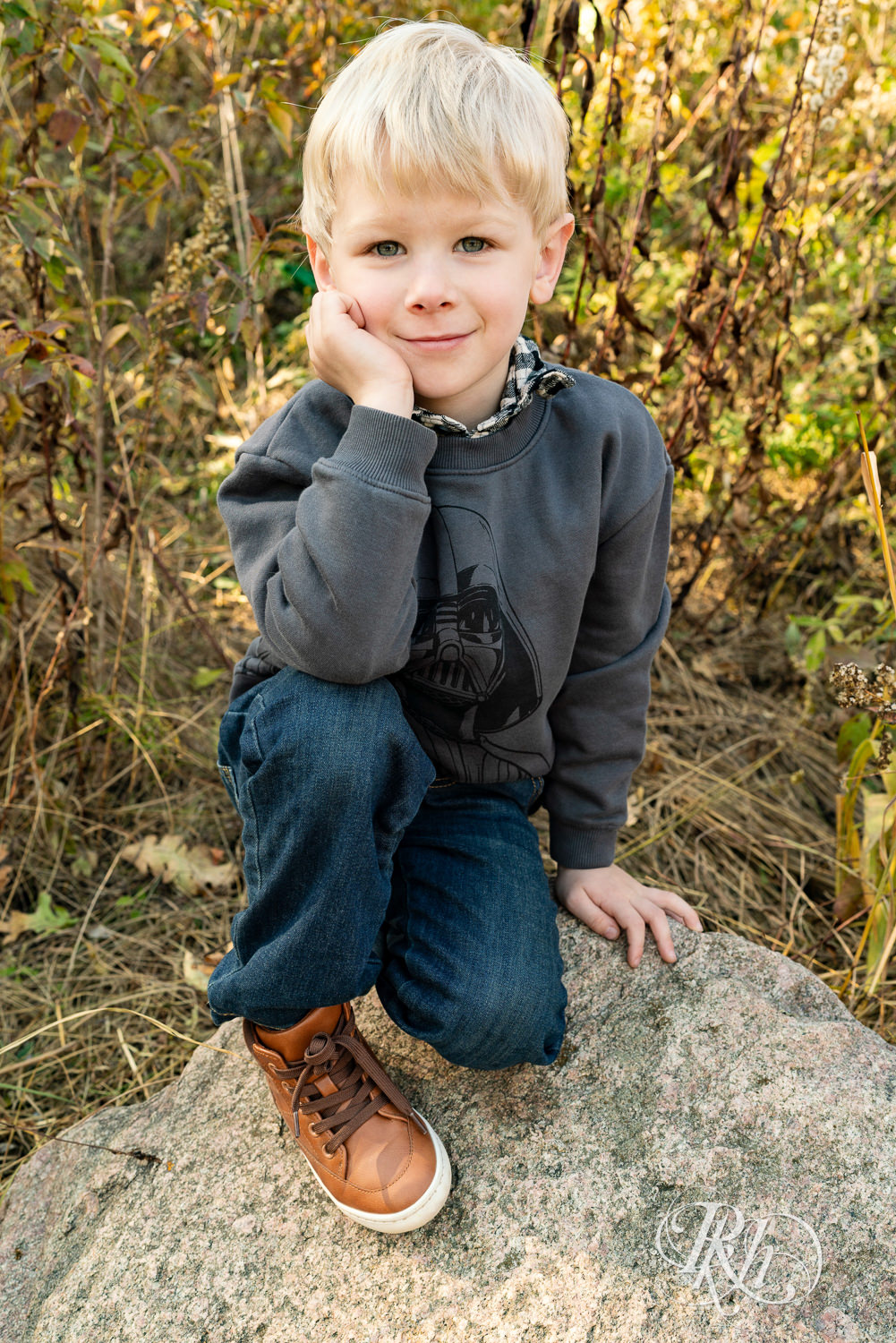 Little blond boy in Darth Vader shirt smiles during fall morning family photos in Lebanon Hills Regional Park in Eagan, Minnesota.