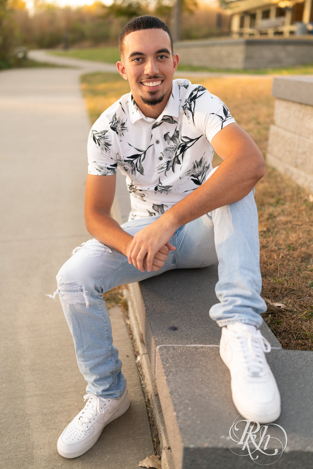 Black senior boy smiles during senior sunset photography in Eagan, Minnesota.