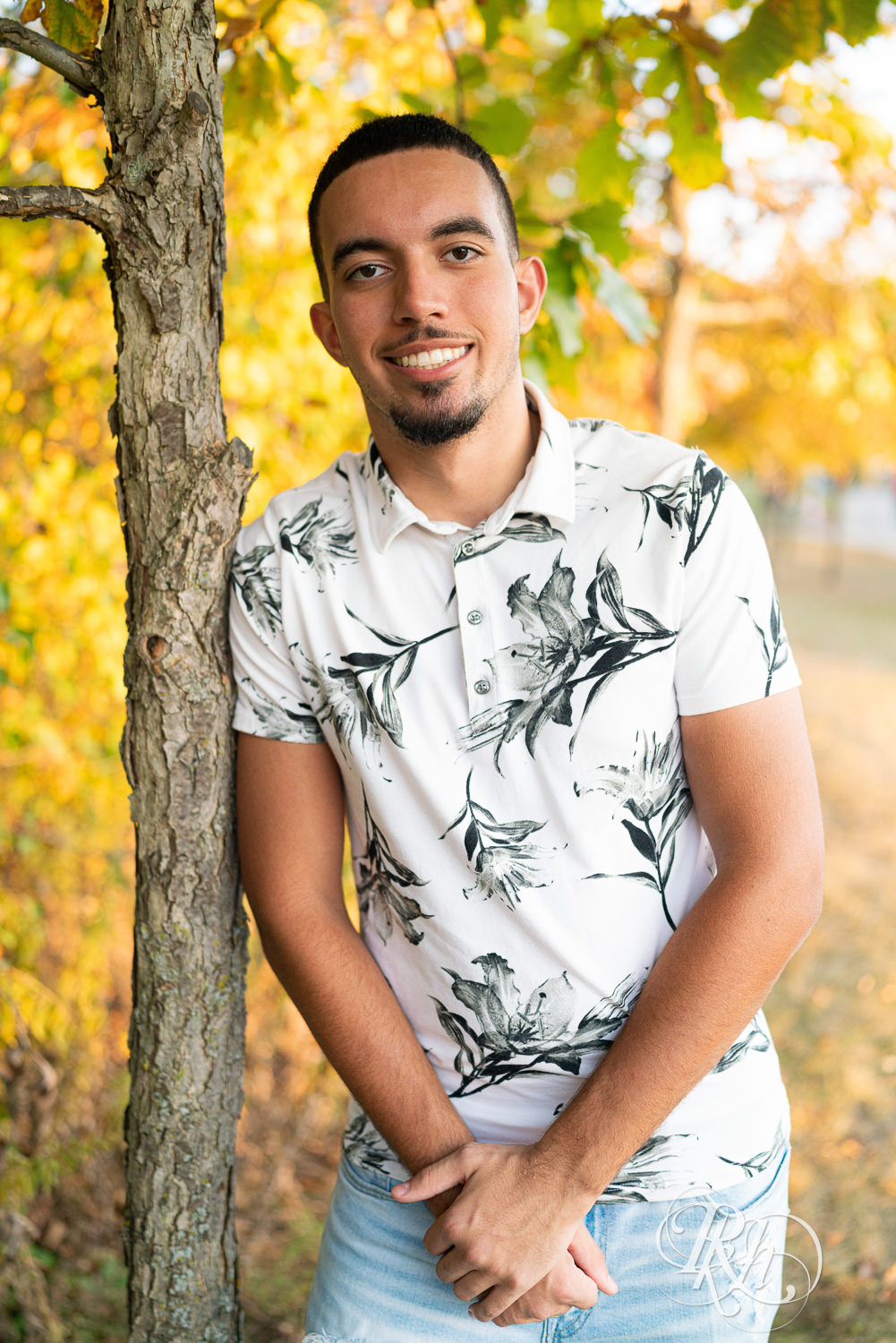 Black senior boy smiles during senior sunset photography in Eagan, Minnesota.